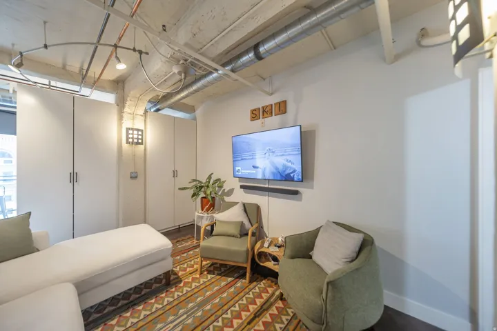 Industrial-style living space featuring exposed ductwork and concrete ceilings