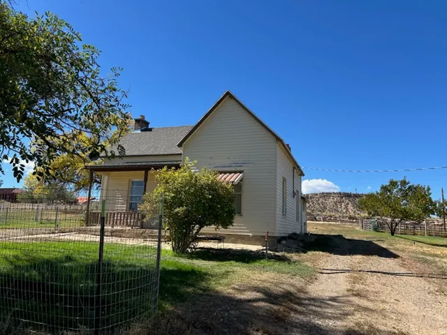 Single-story residence with a gabled roof, covered front porch, and a gravel driveway