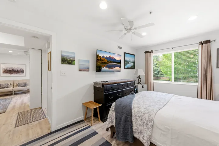 Bedroom featuring a large window, light wood-finish flooring, recessed lighting, and a ceiling fan