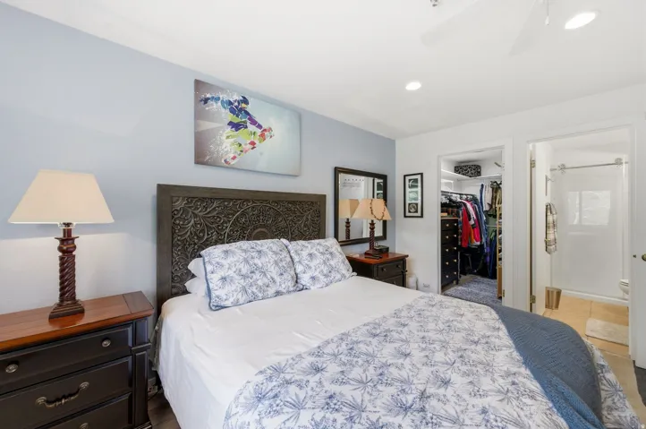 Bedroom featuring a detailed wood headboard, light blue accent wall, recessed lighting, and a ceiling fan