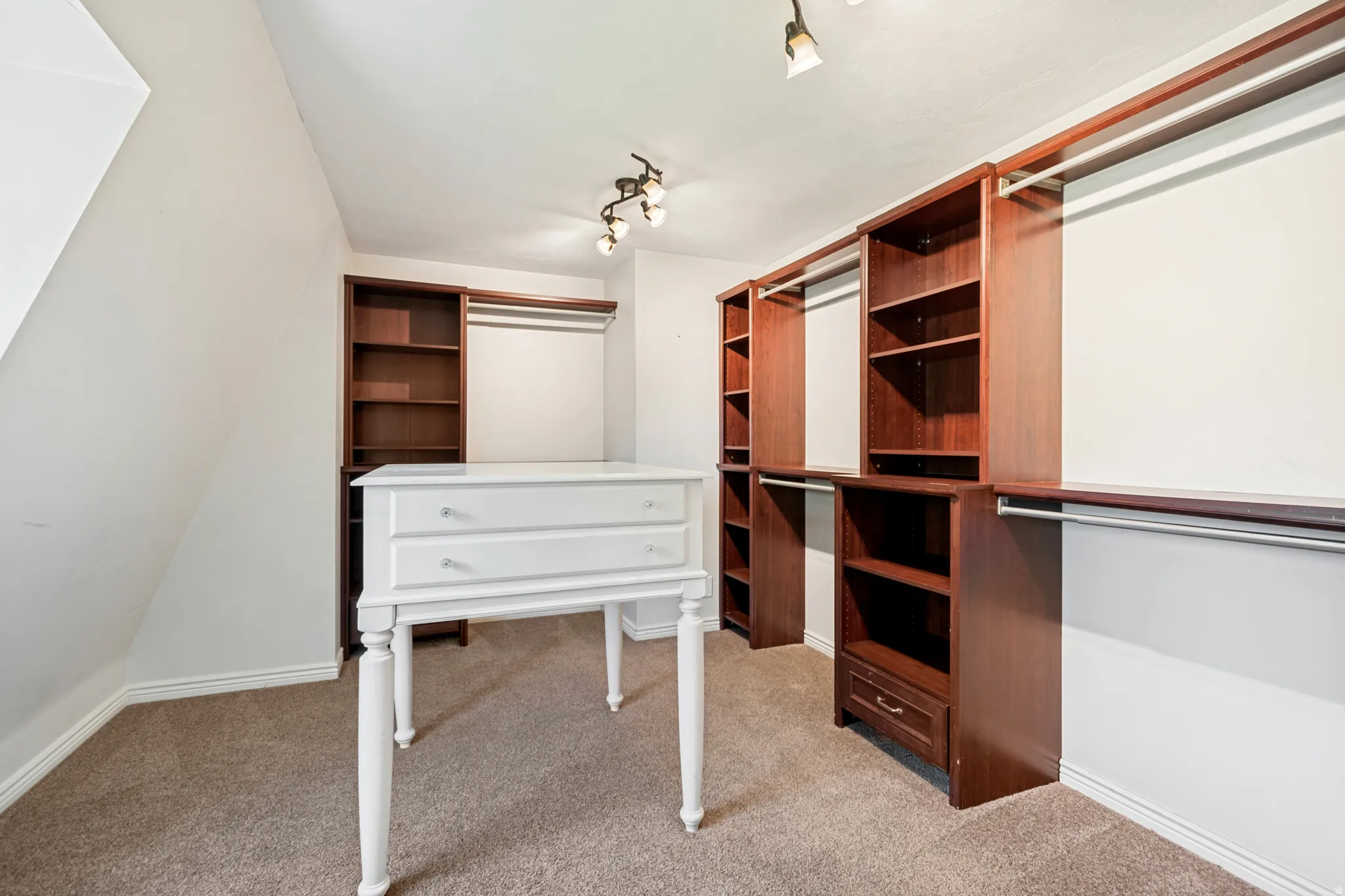 Built-in closet system featuring warm wood-finish shelving and hanging rods
