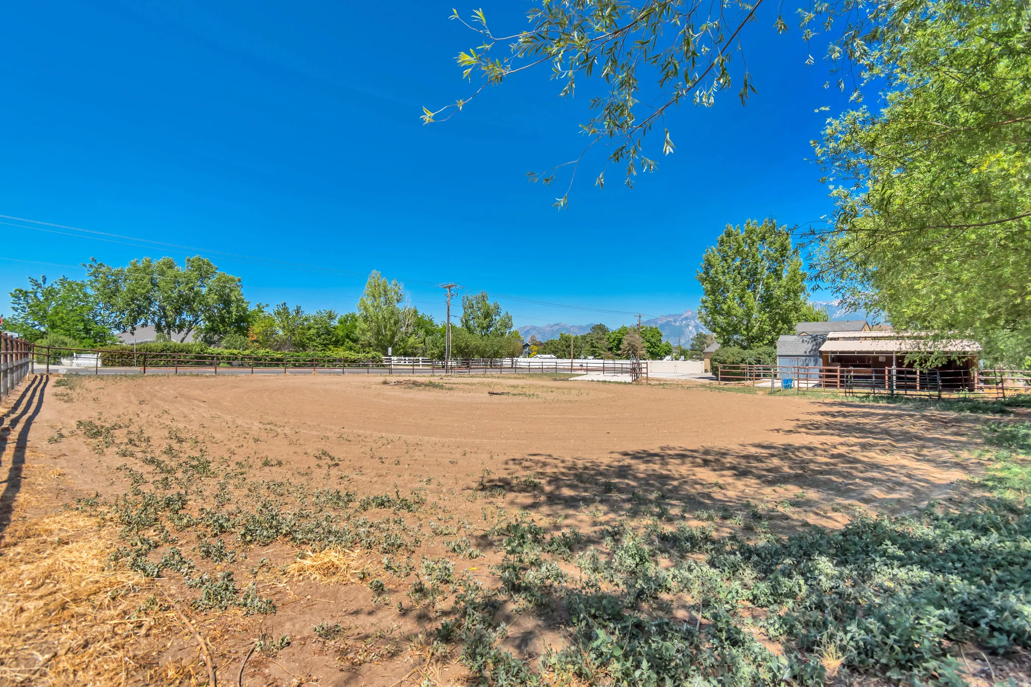 Expansive outdoor arena featuring a dirt surface and a perimeter fence