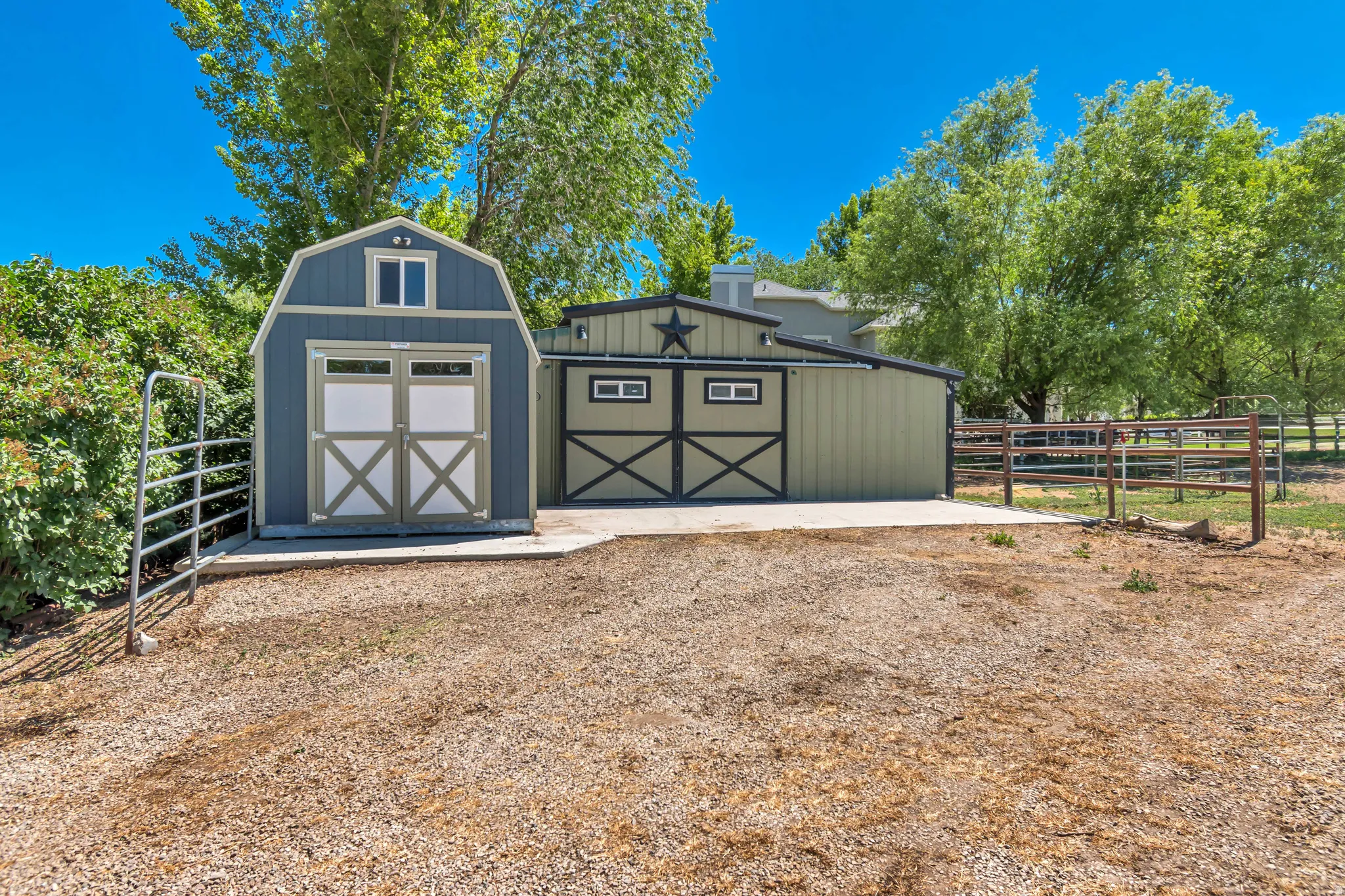 Two tone outbuildings featuring a gambrel roof shed with double doors and an additional structure with a star detail