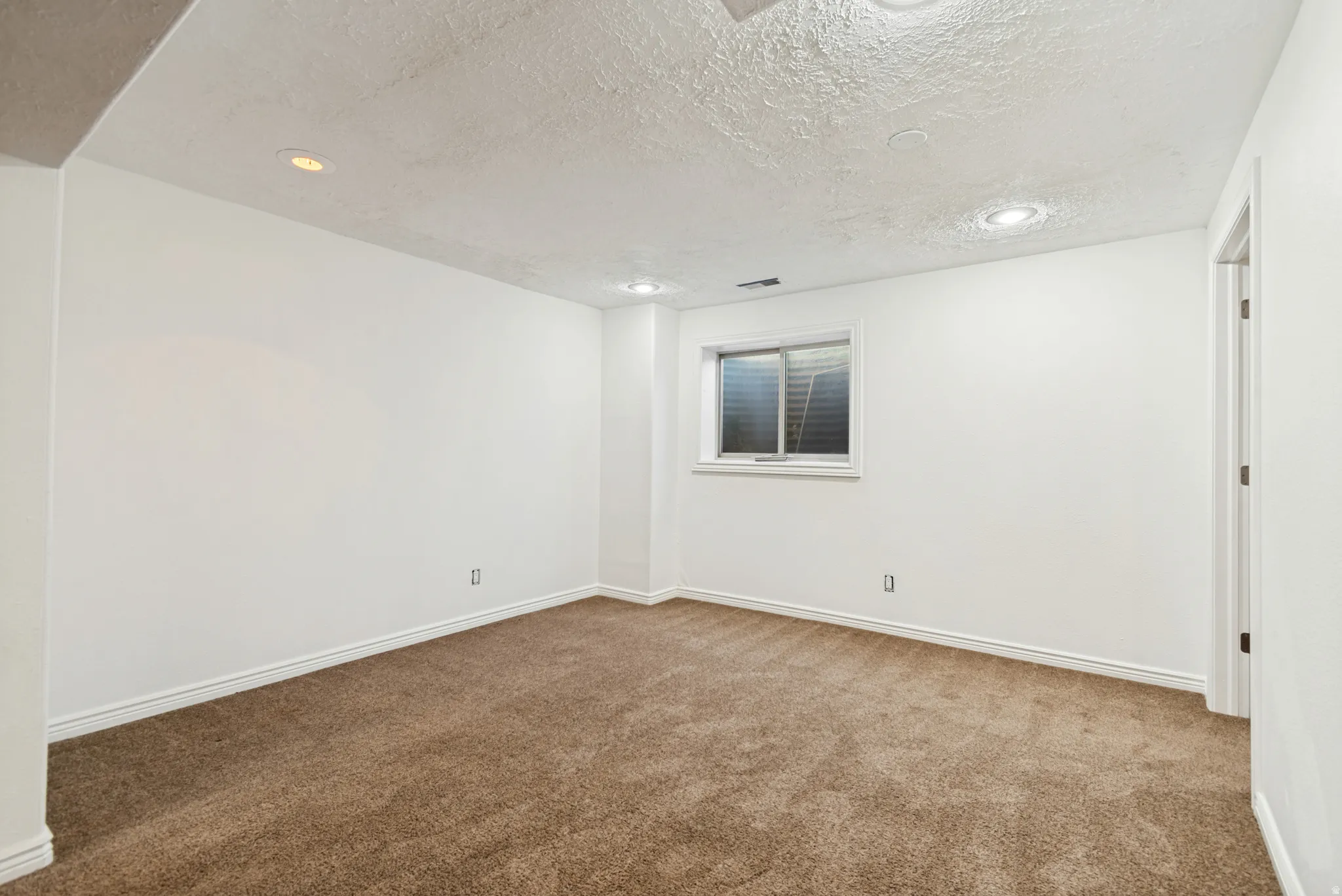 Room featuring brown carpeting, white baseboards, and white painted walls