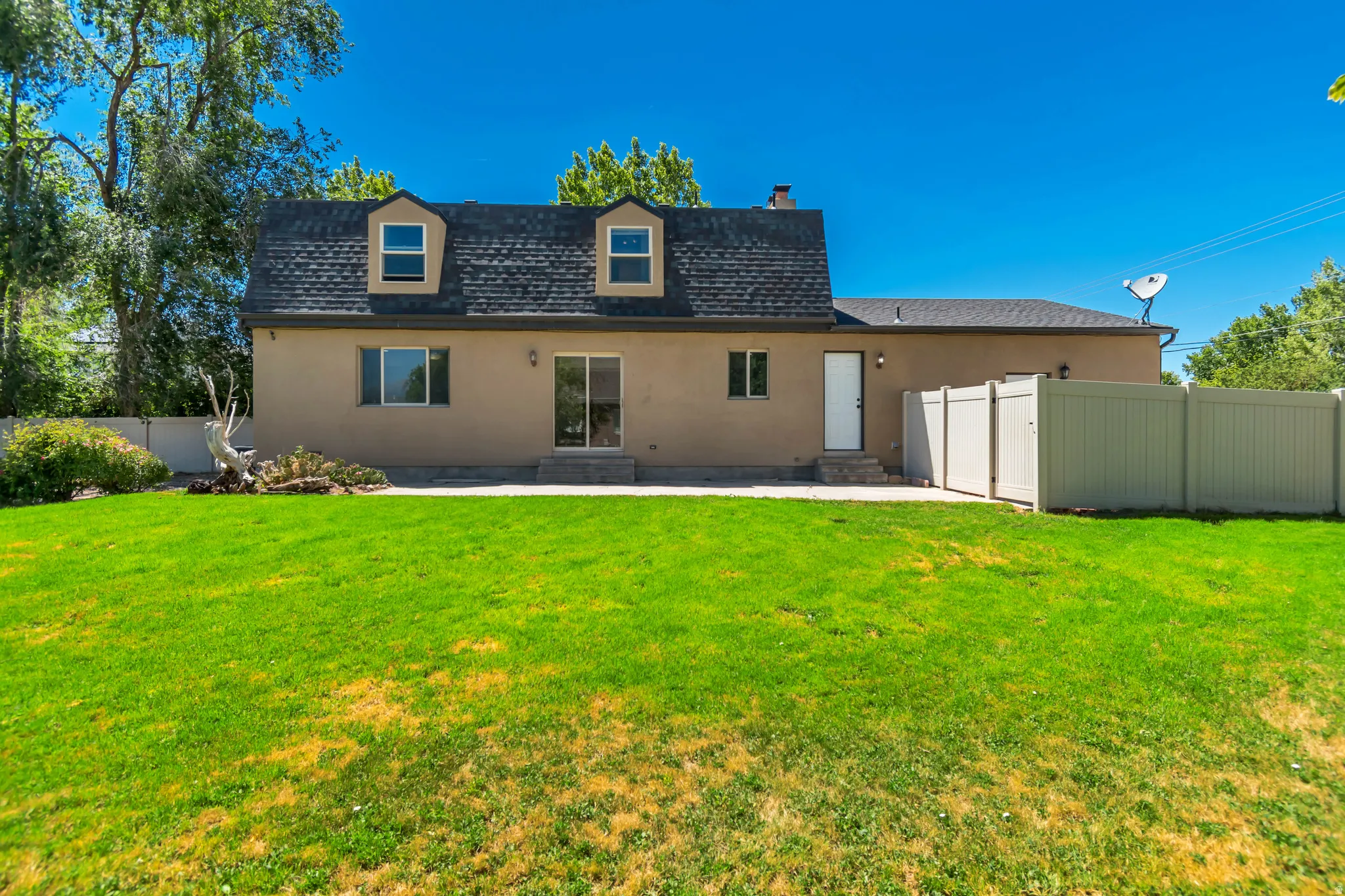 Spacious backyard featuring an expansive lawn, a patio, and a privacy fence