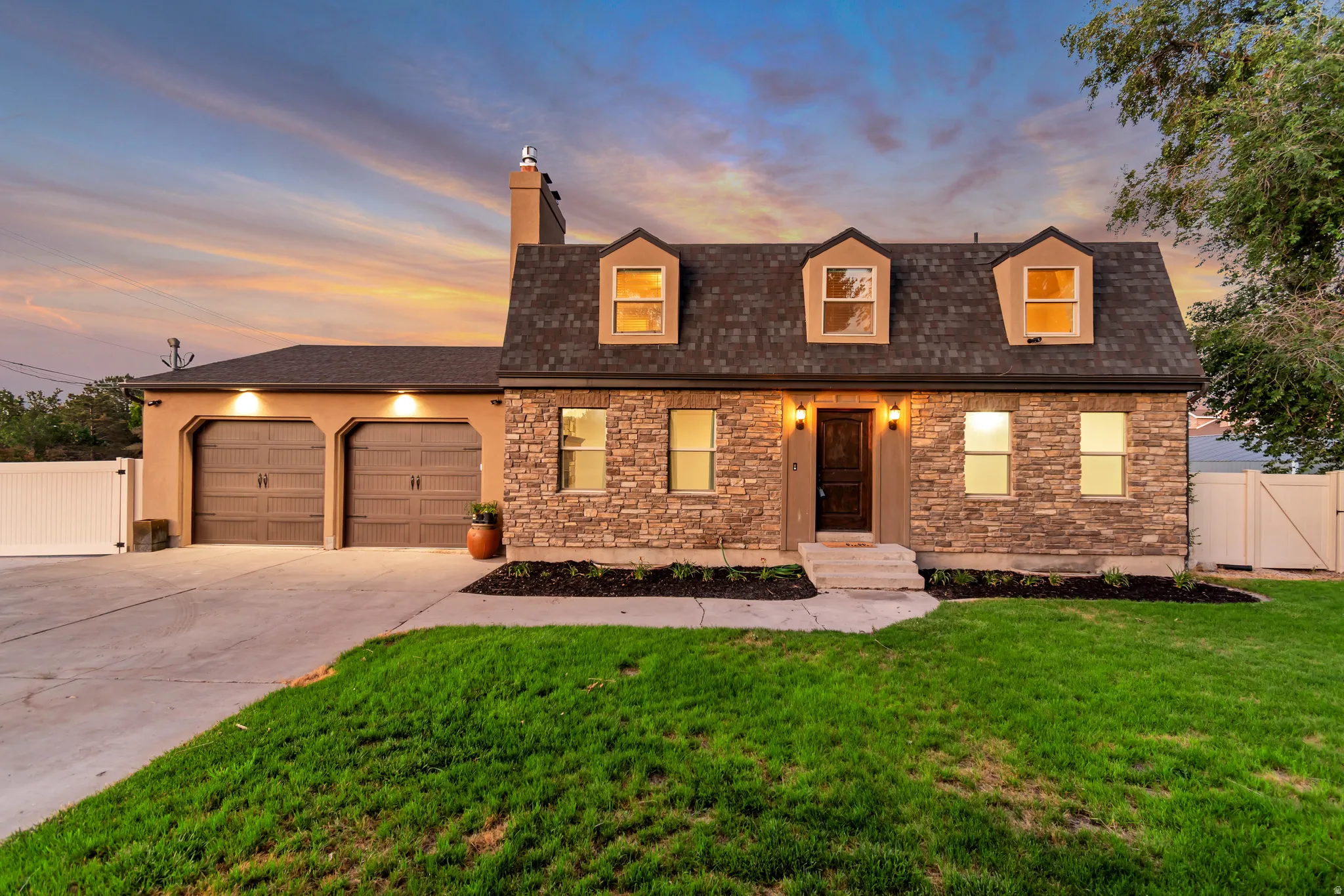 Stone and stucco exterior featuring a dark asphalt shingle roof