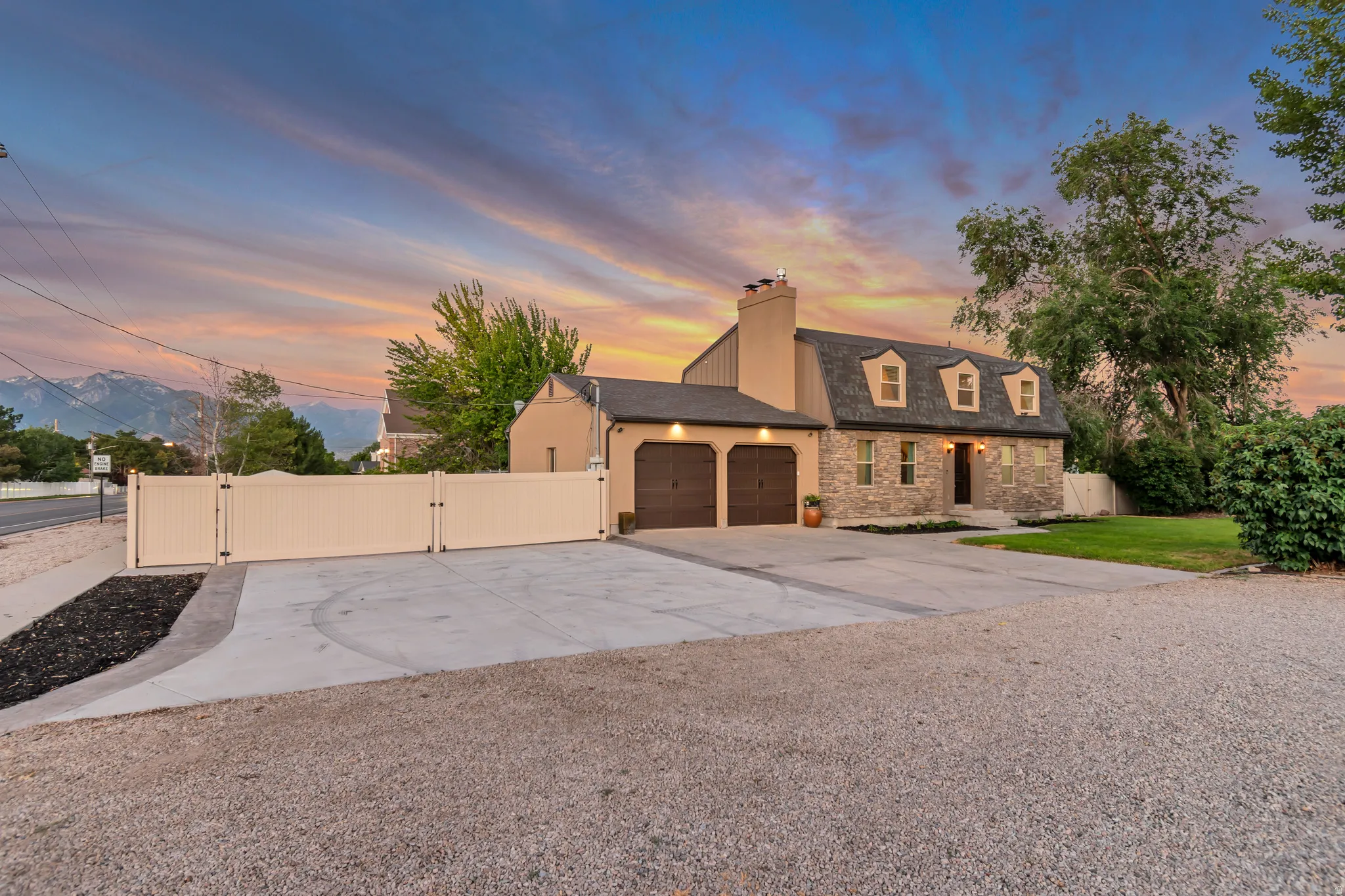 Stone and stucco exterior with dark brown garage doors