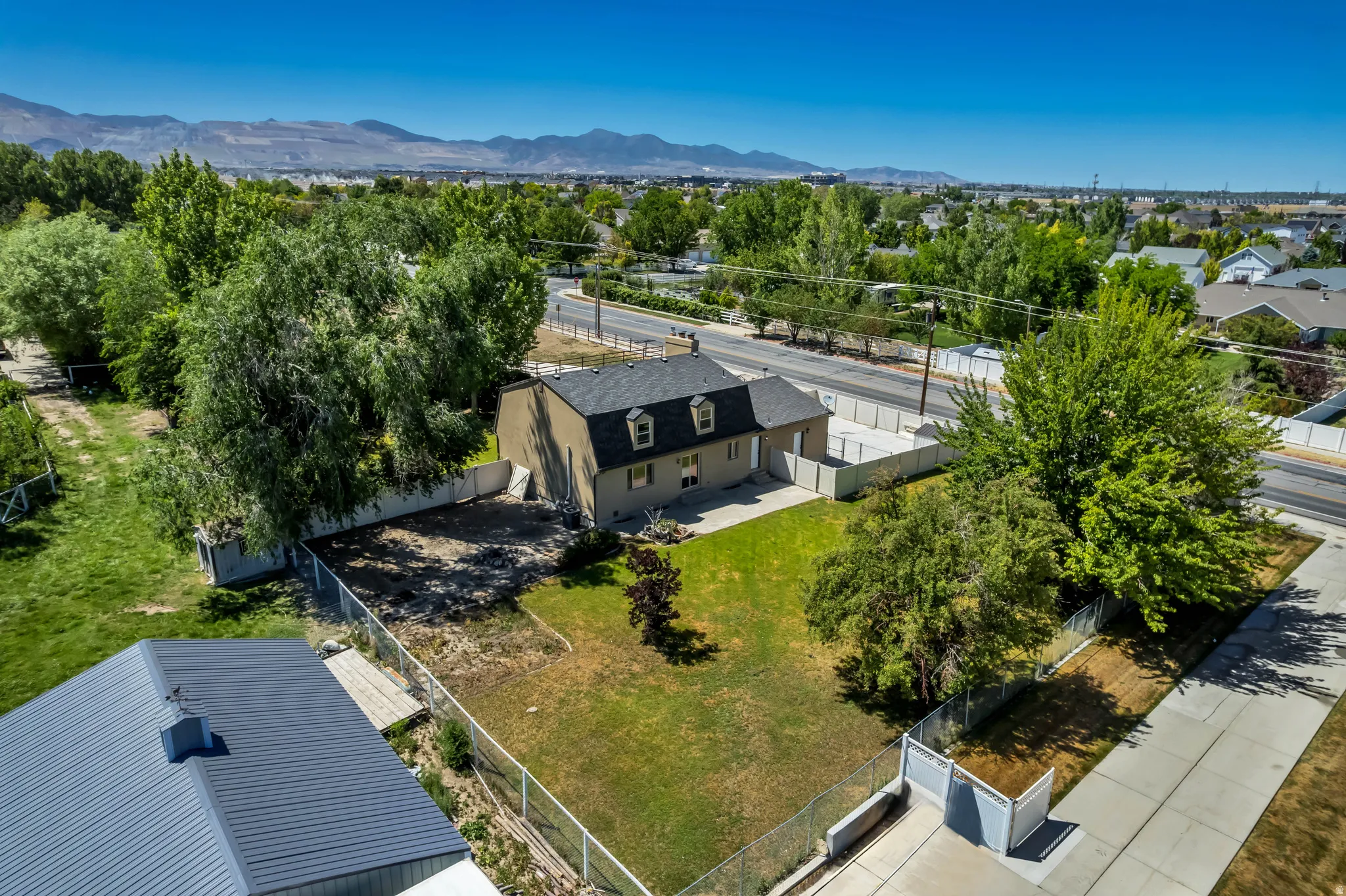 Aerial perspective showcasing a single-story residence with a dormer roofline and a neutral-toned exterior