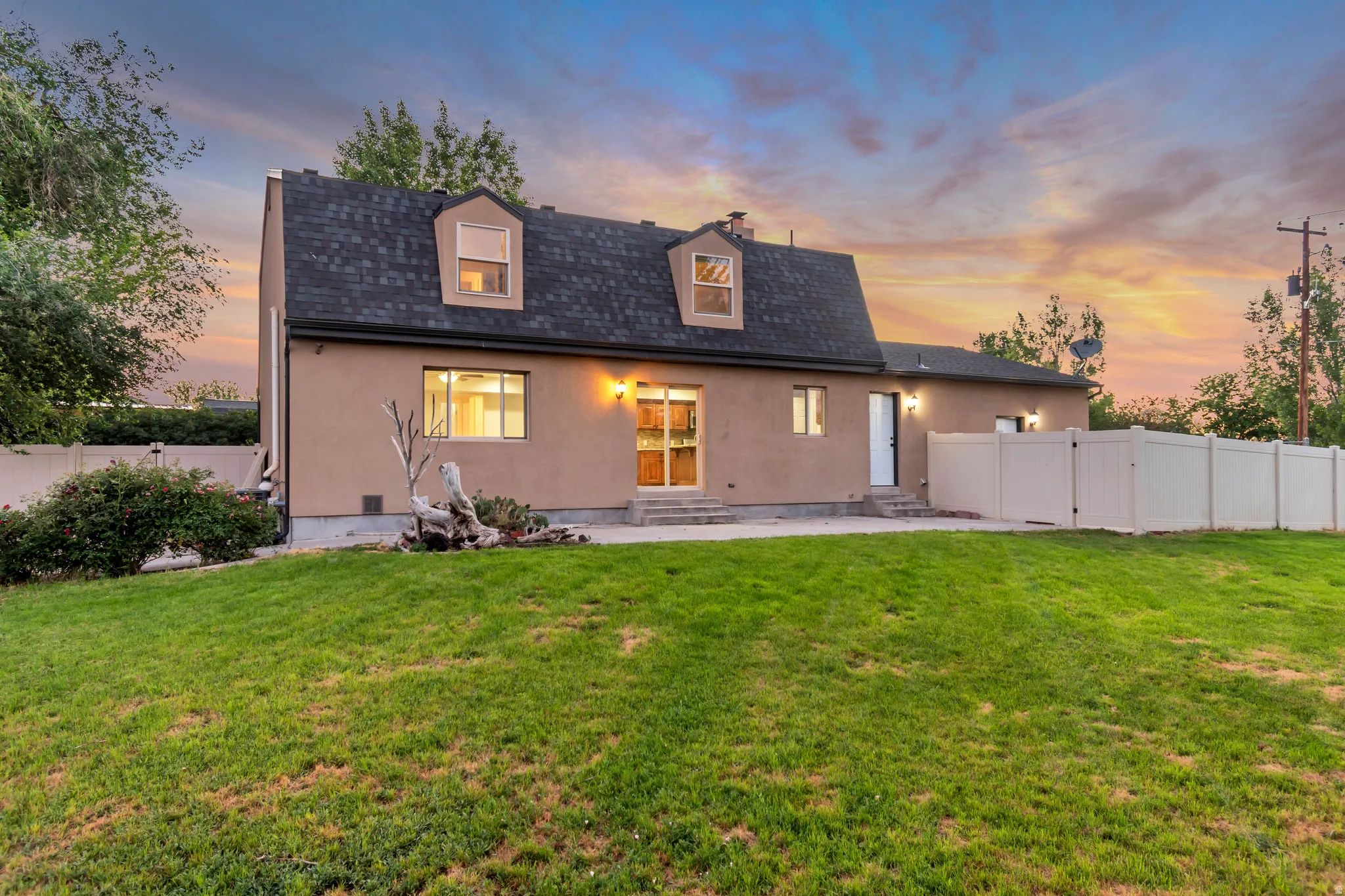 Expansive backyard featuring a sloped lawn and mature perimeter landscaping