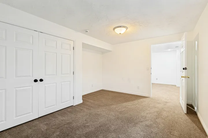 Room featuring light-colored walls and textured carpeting