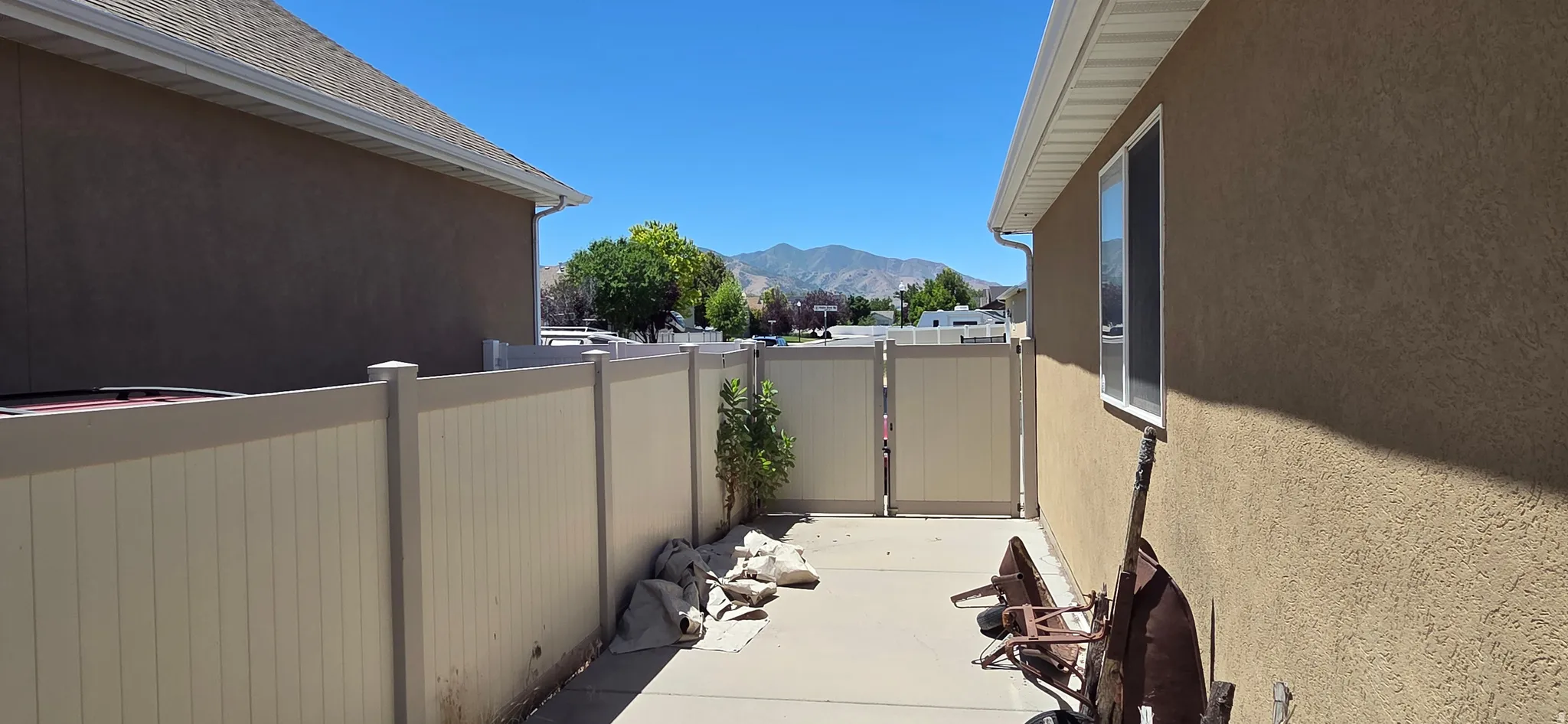 Paved side yard featuring a privacy fence with a gated entrance