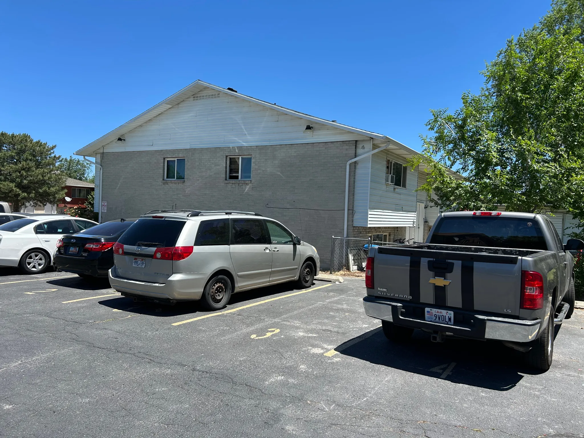 Multi-unit building featuring a gray brick facade and white horizontal siding