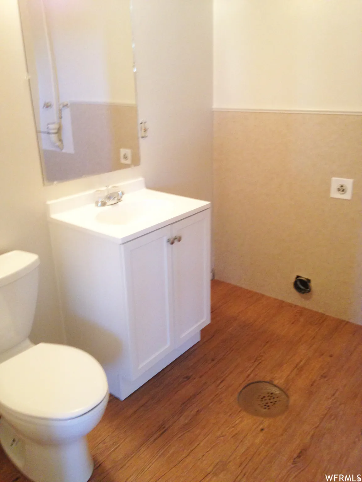 White vanity with an integrated sink, polished chrome faucet, and mirrored cabinet