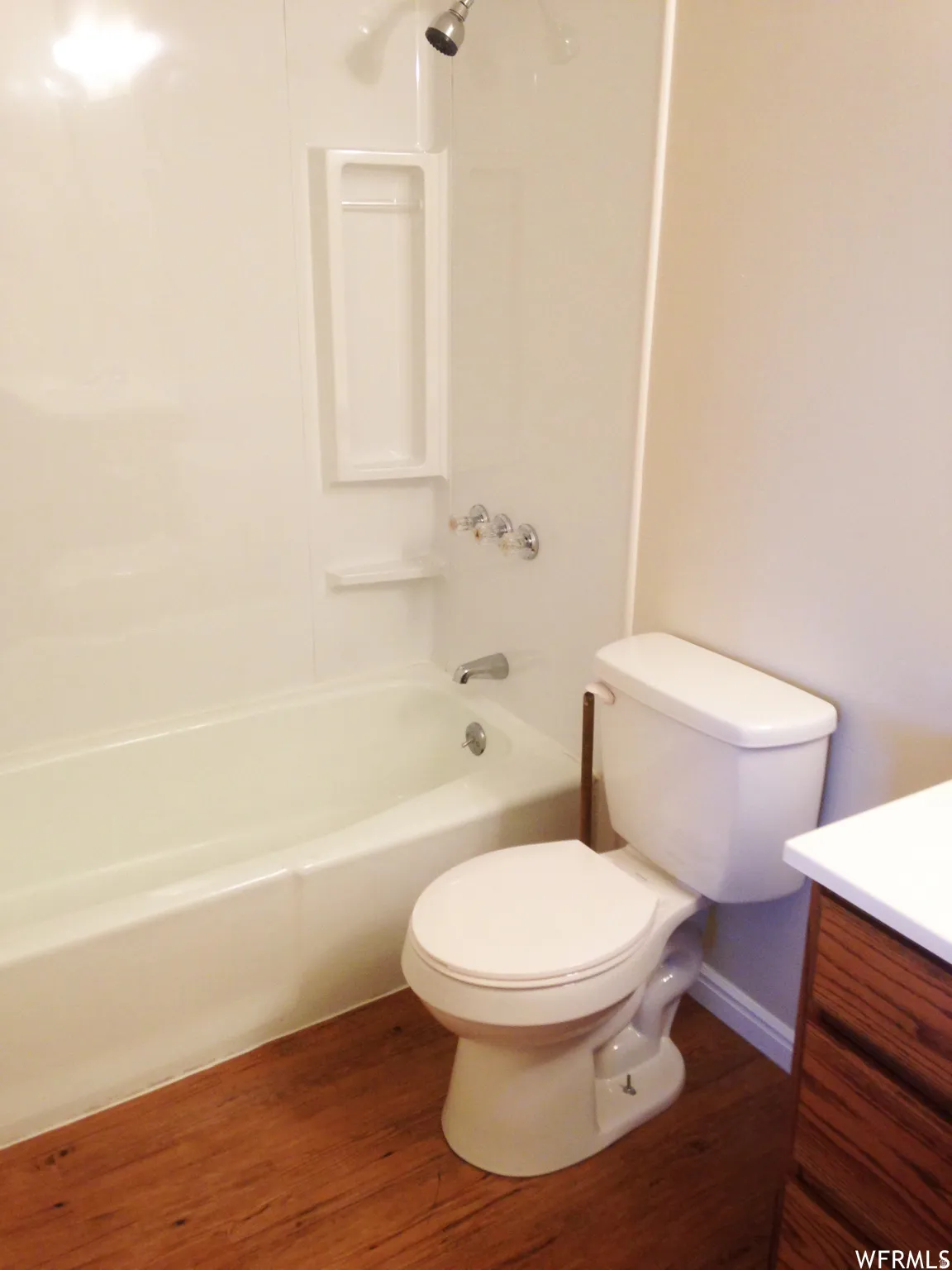 Bathroom featuring a white bathtub and shower combination with chrome fixtures
