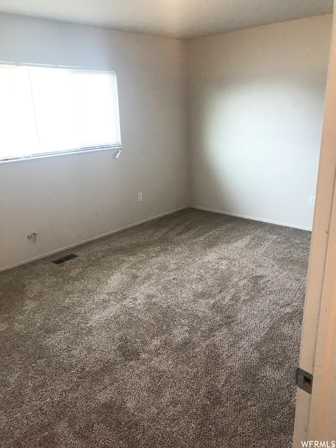 Neutral-toned carpeting extends throughout this room, complemented by light-colored walls