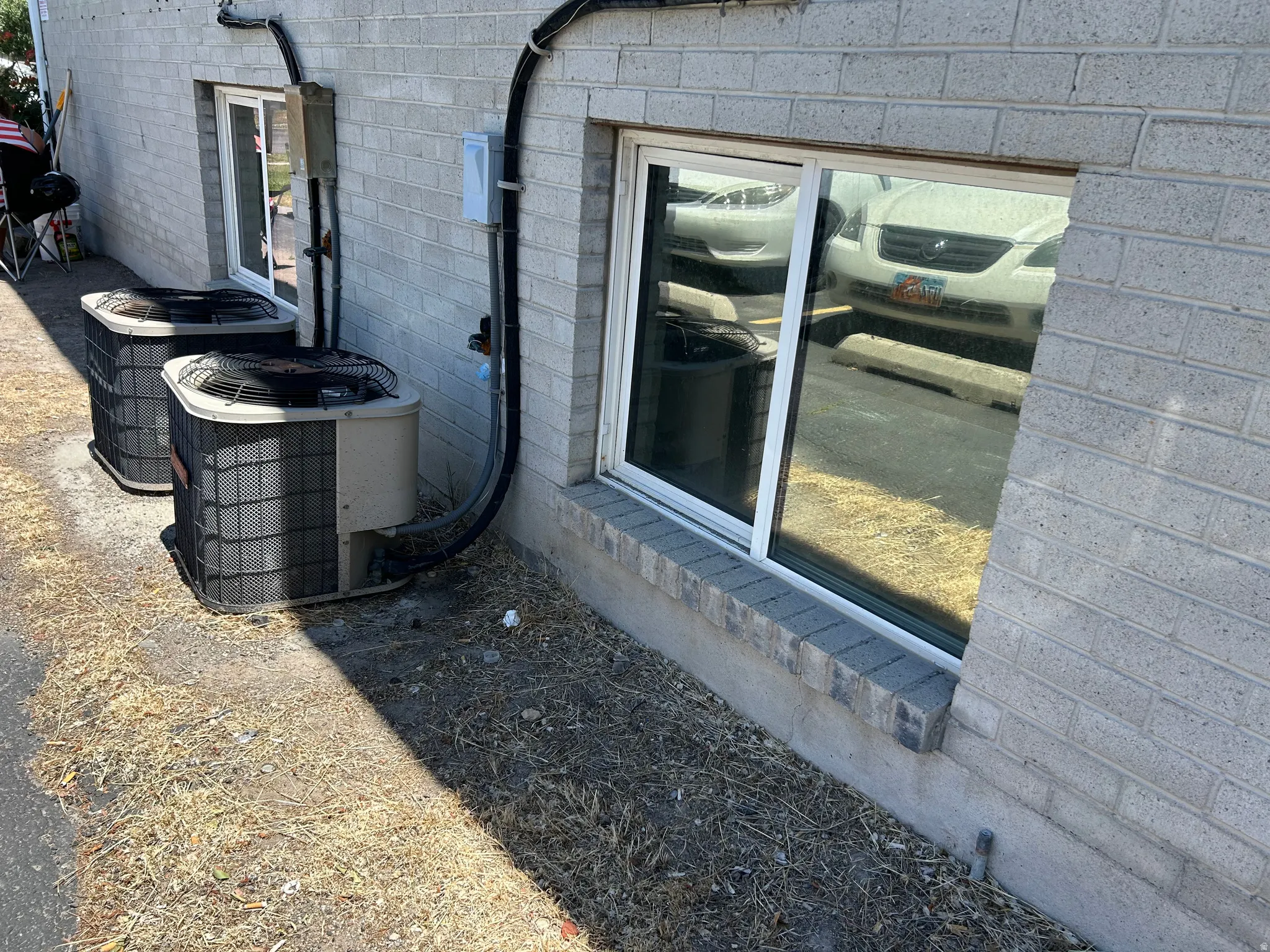 Light gray brick exterior featuring two ground-level sliding windows with white frames