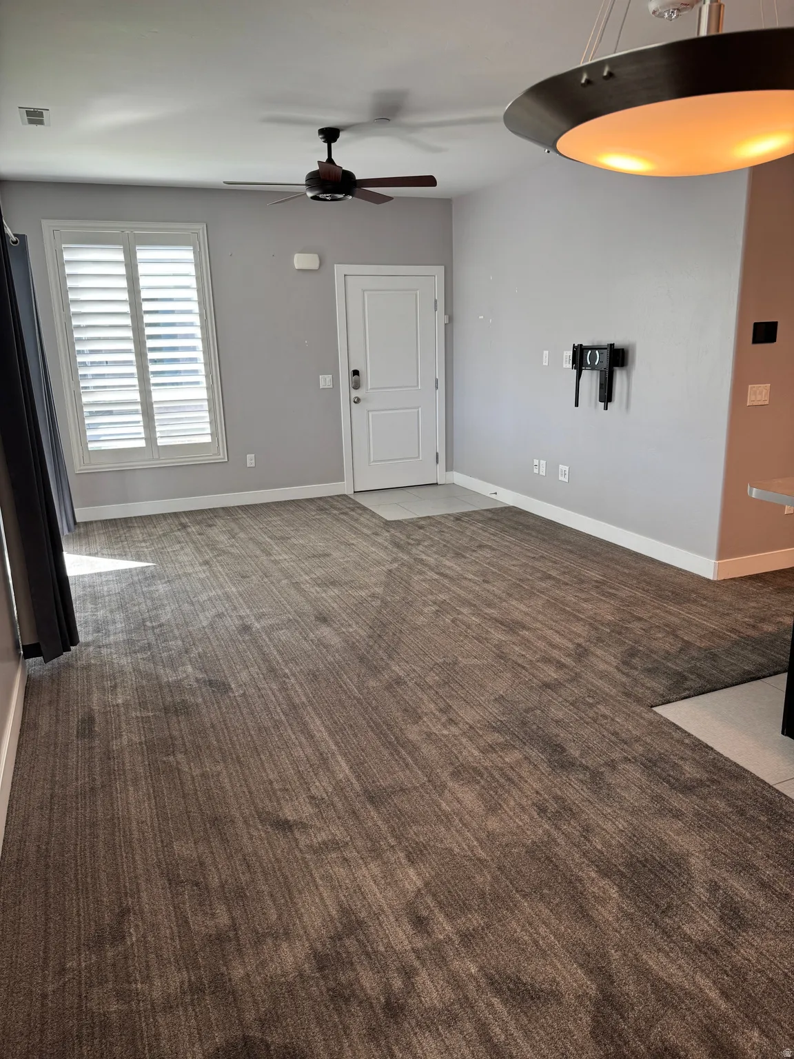 Open-concept room featuring neutral tone carpeting and light gray walls