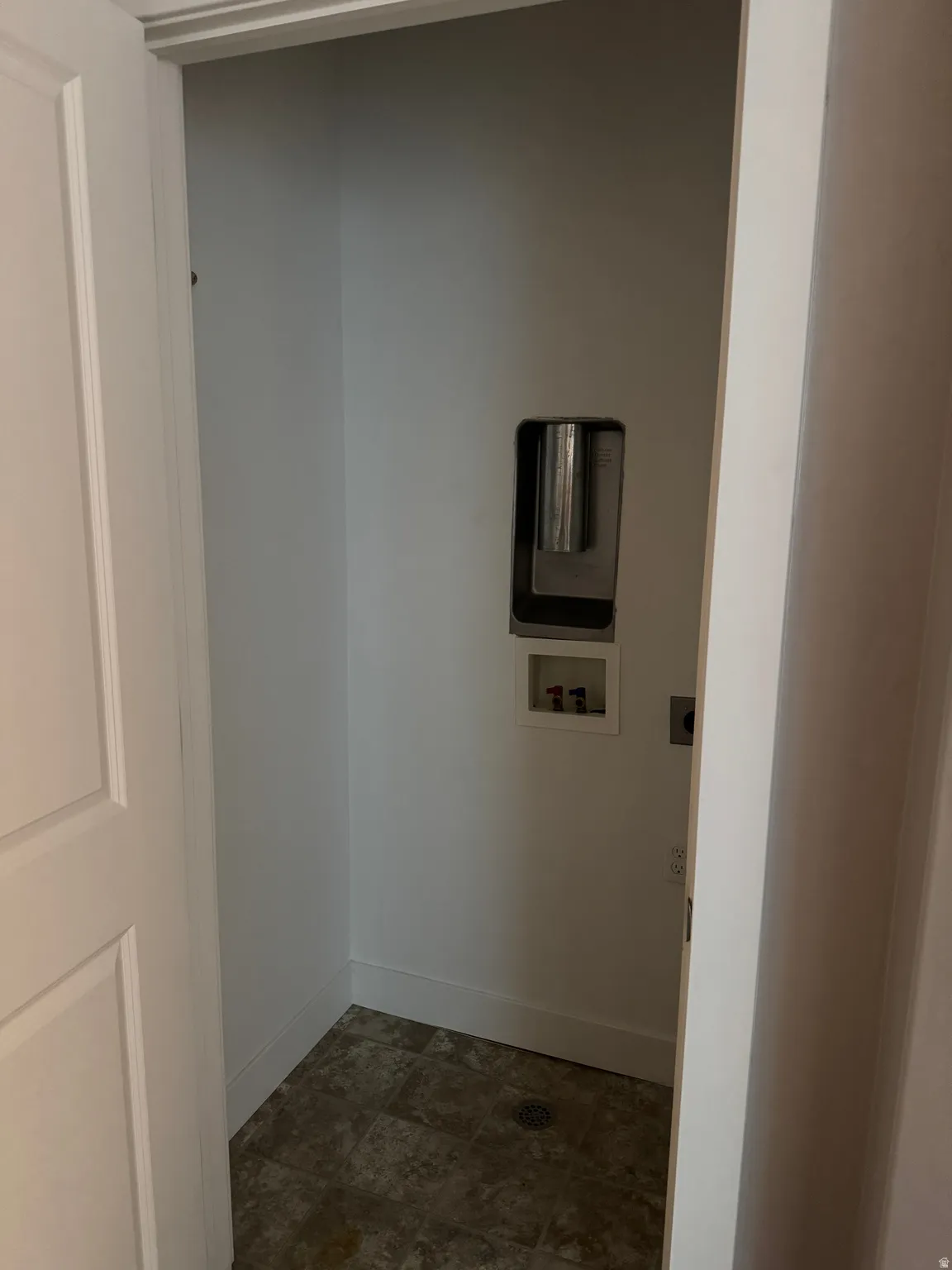 Utility closet with tiled flooring, white walls, and hookups for laundry appliances