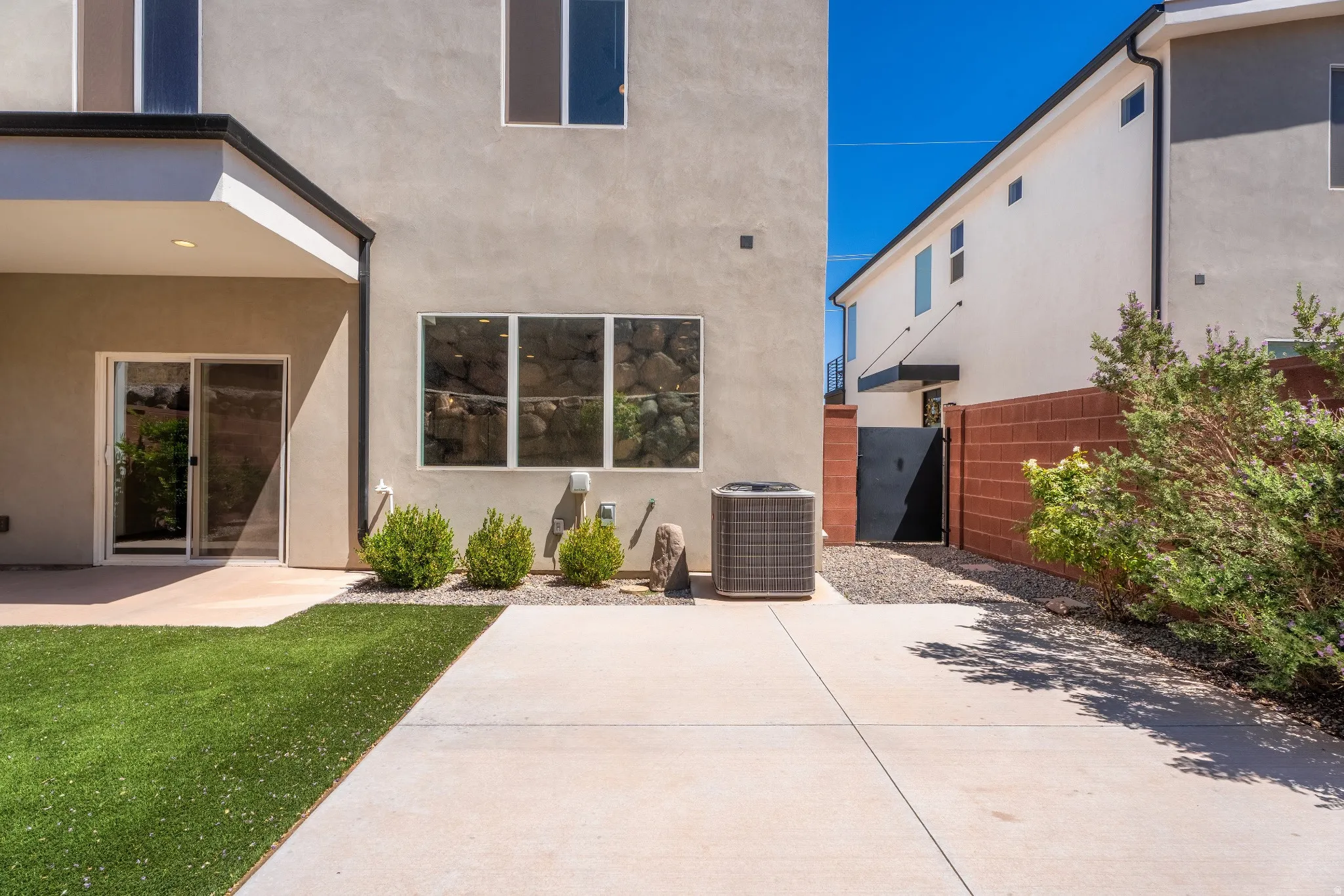 Concrete patio and walkways complement artificial turf landscaping