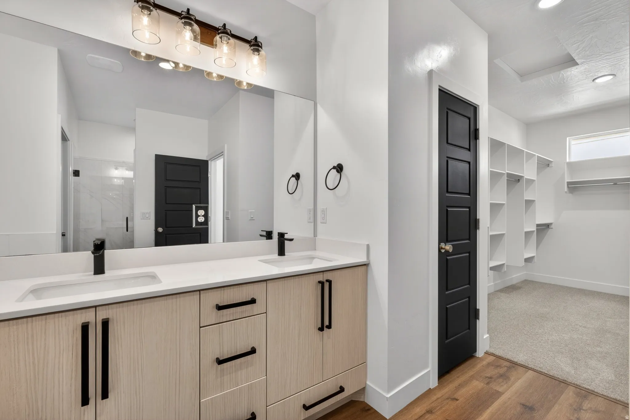 Dual vanity featuring light wood-finish cabinetry and white countertops