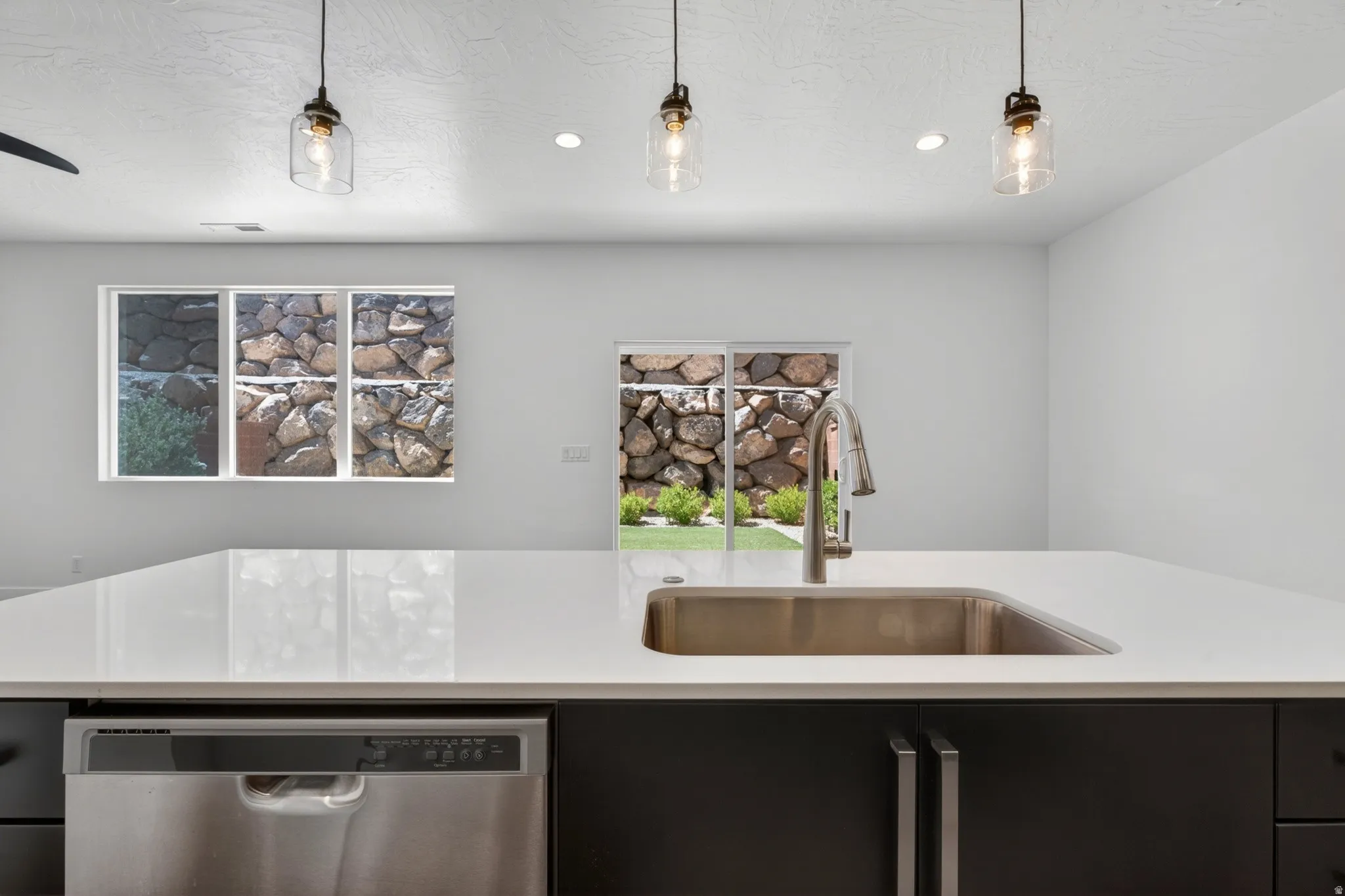 Kitchen island featuring a stainless steel undermount sink and pull-down faucet