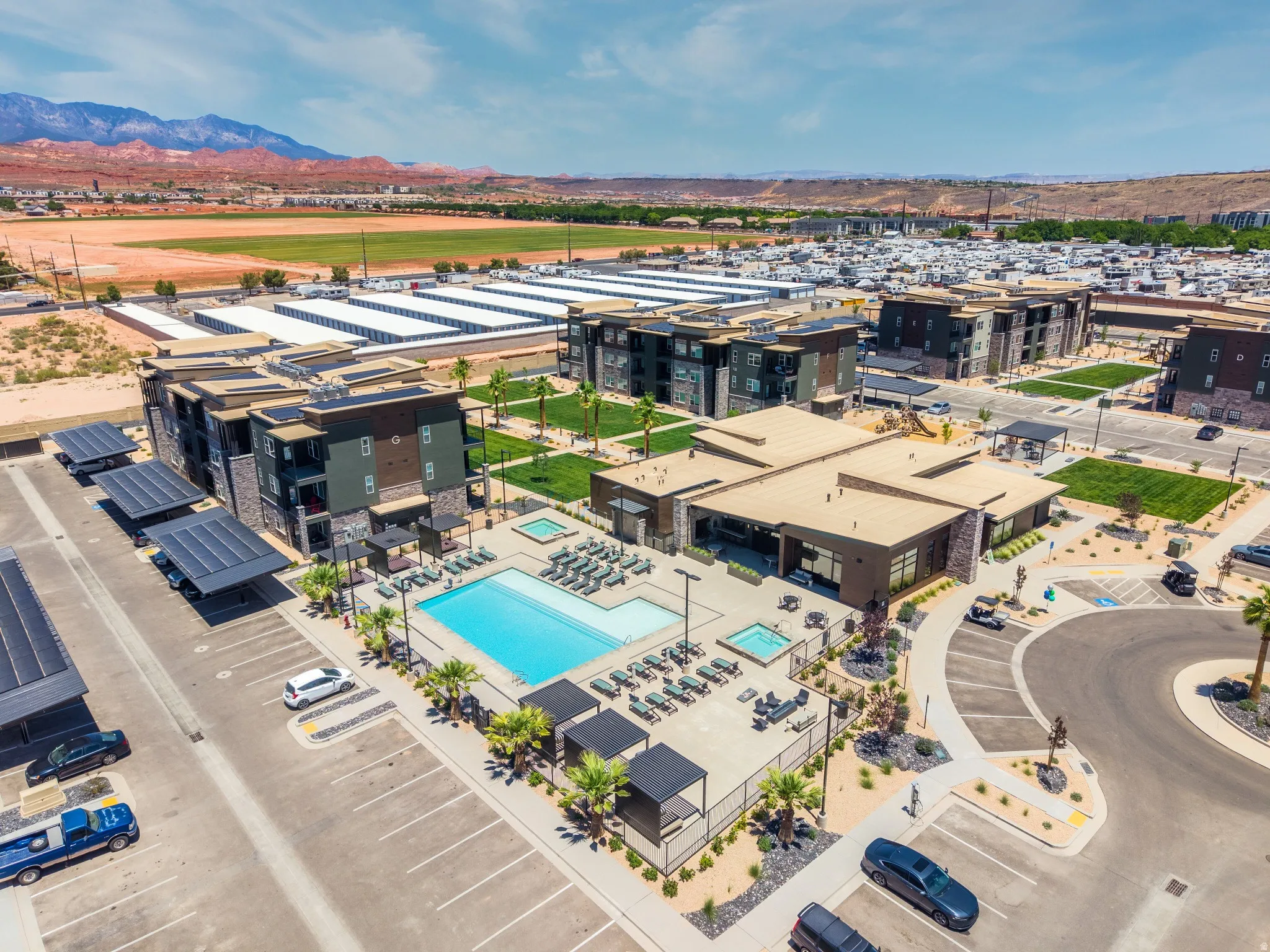 Community amenity area featuring a large swimming pool, hot tub, and an outdoor lounge space with shaded pergolas