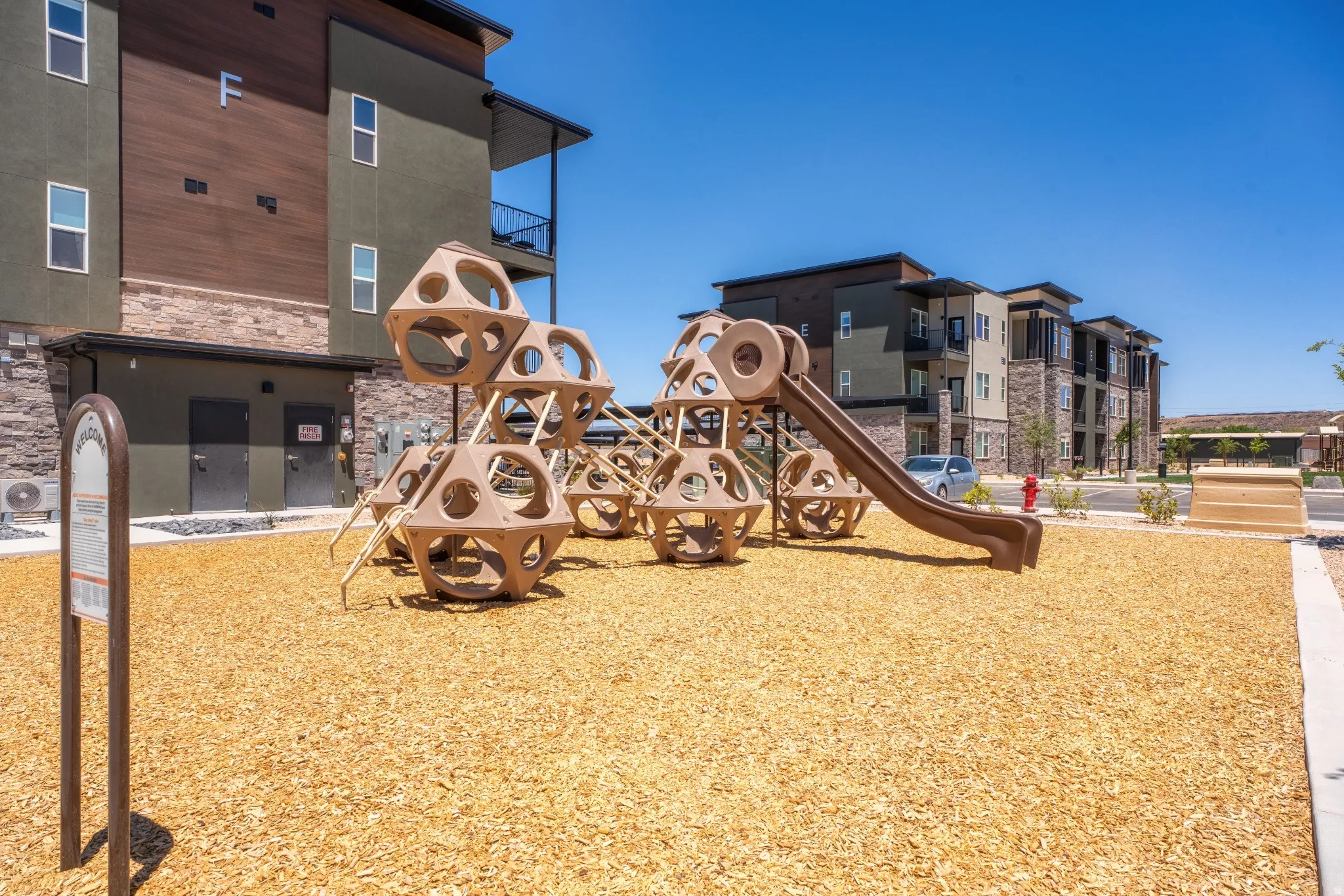 Dedicated playground area featuring a composite play structure with a slide and climbing elements