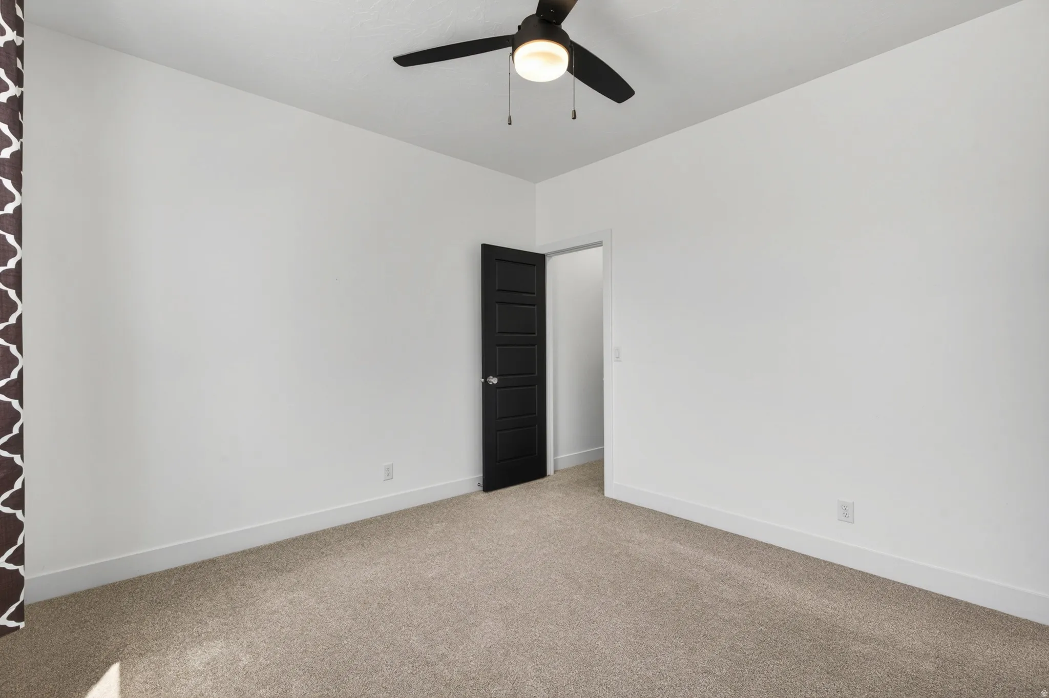 Neutral tone carpeted room with white walls and baseboards