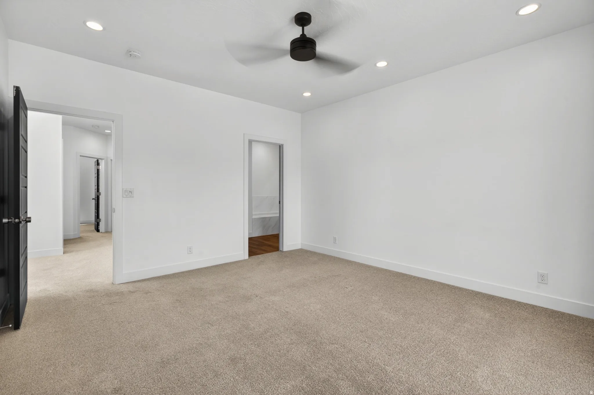 Spacious room with plush carpet flooring, recessed lighting, and a contemporary ceiling fan