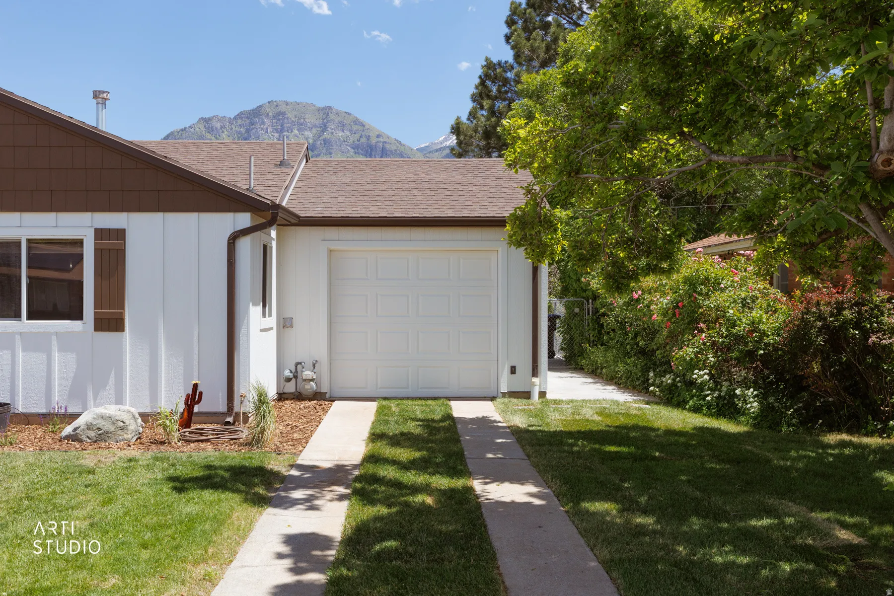 Single-car garage with a white overhead door and concrete driveway