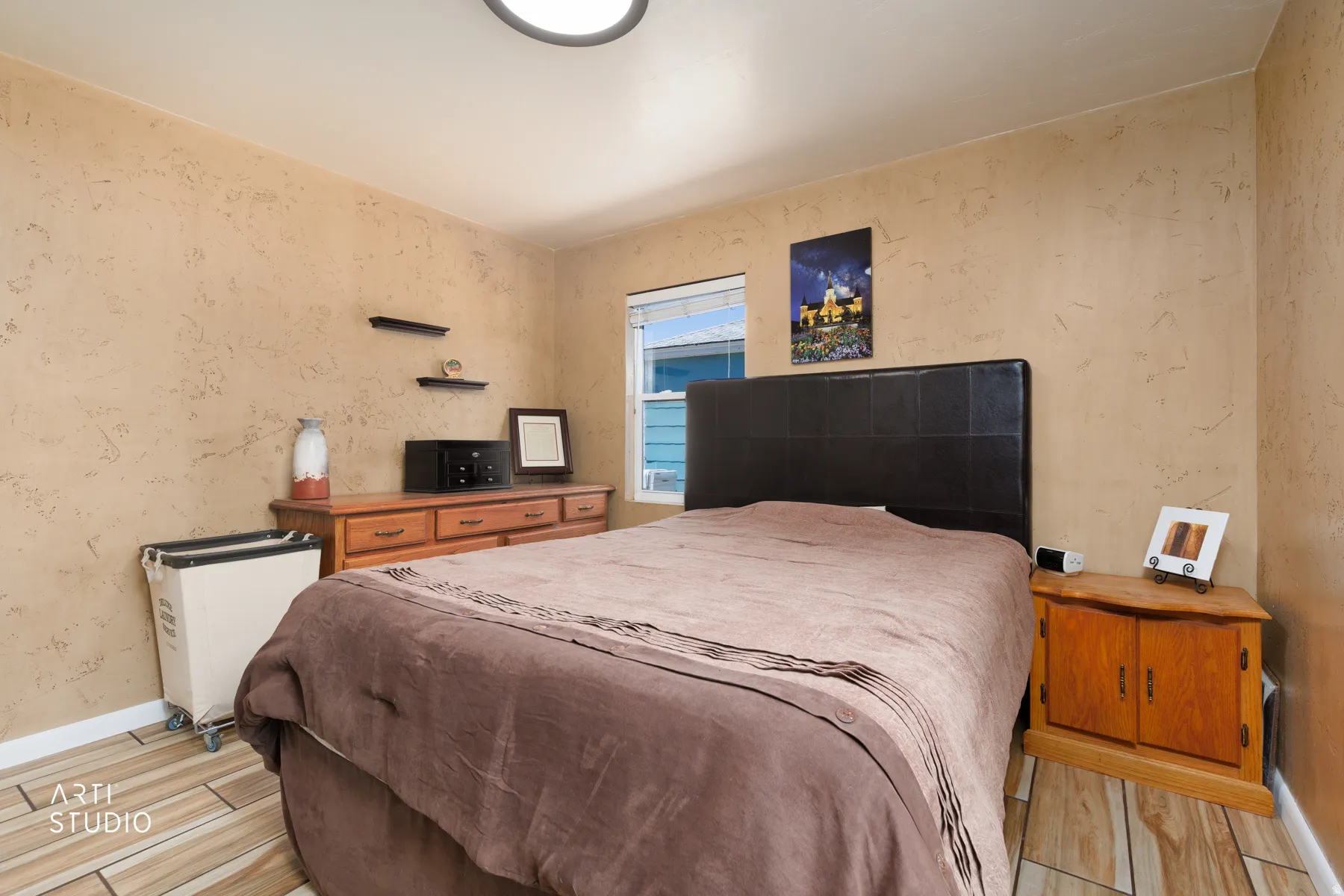 Room with textured walls and wood-finish tile flooring