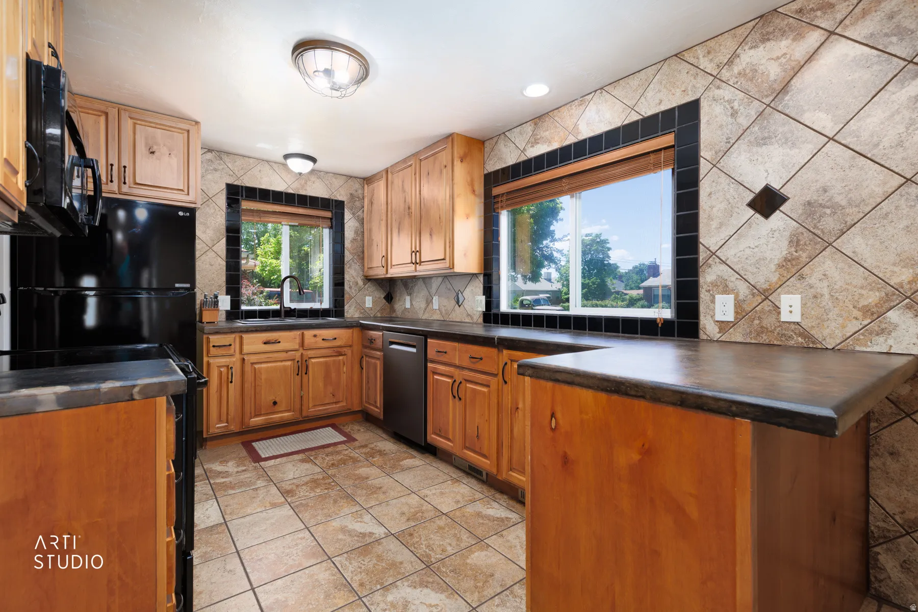Kitchen featuring wood cabinetry, dark countertops, and a tiled backsplash