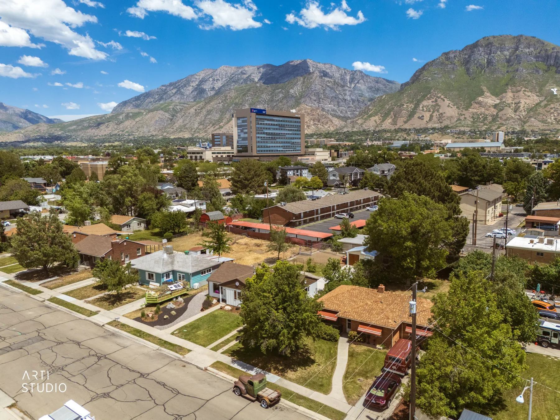 Mountainous terrain backdrop featuring a residential street with diverse housing styles