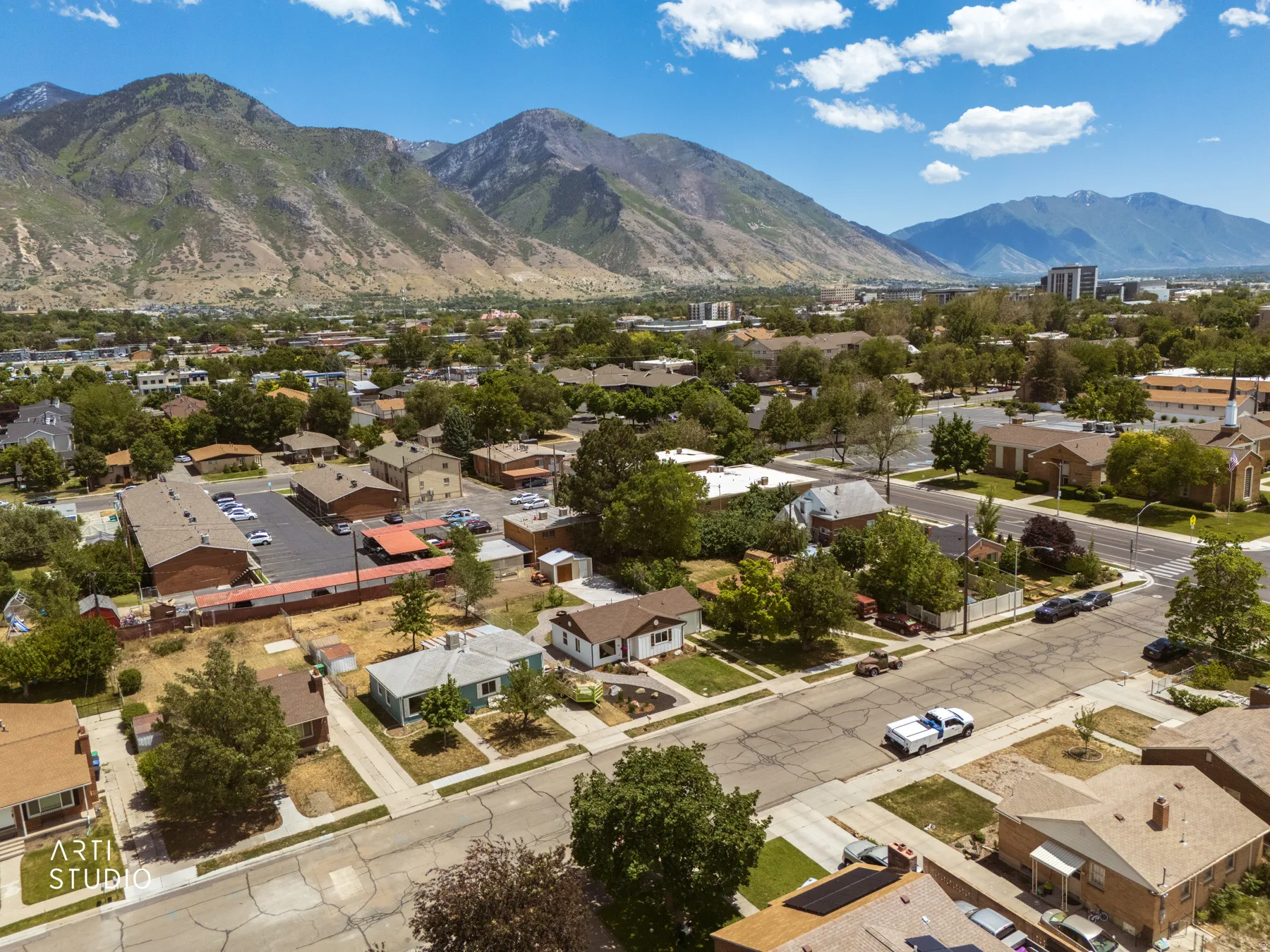 Expansive mountain backdrop framing a residential neighborhood with mature trees and established homes