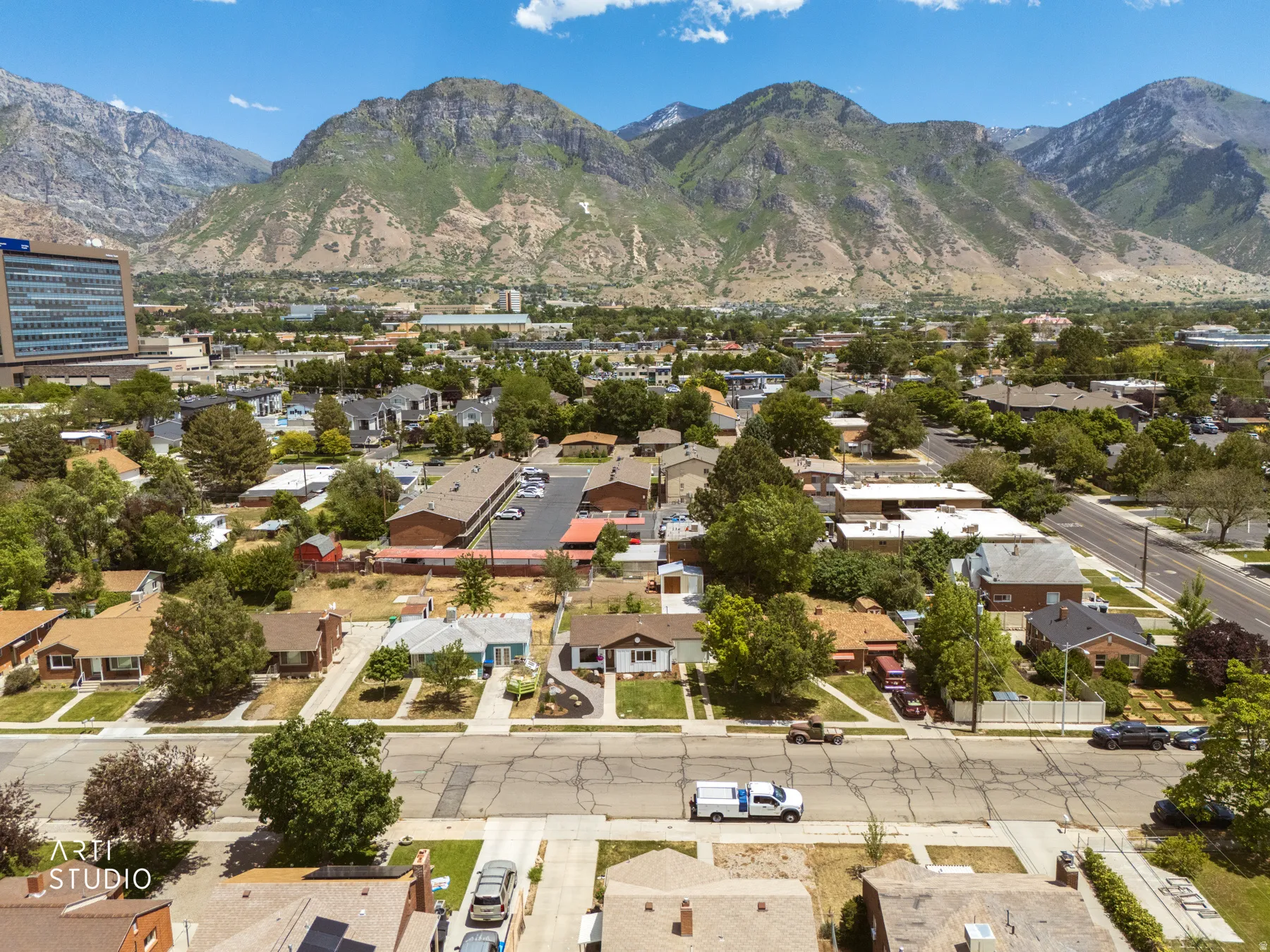 Residential neighborhood with mature trees and a clear mountain backdrop