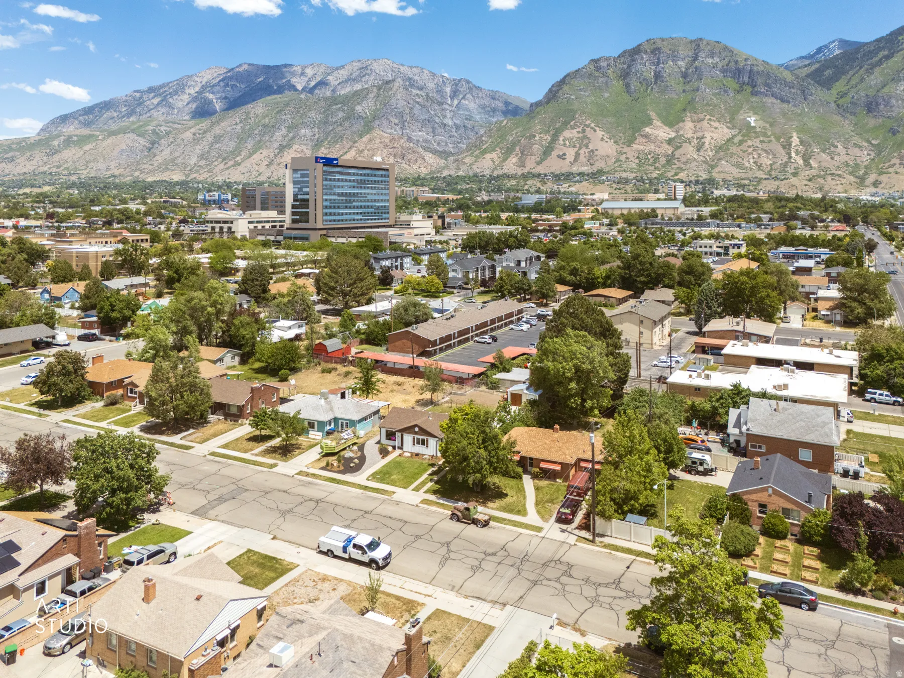 Residential area featuring a variety of architectural styles, mature trees, and mountainous terrain