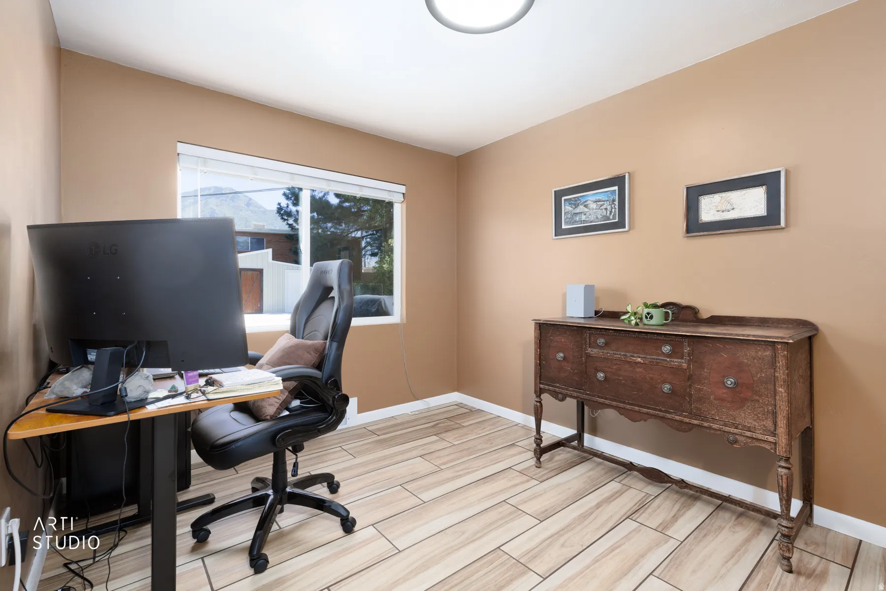 Versatile room featuring wood-finish tile flooring, neutral wall tones, and a large window with horizontal blinds