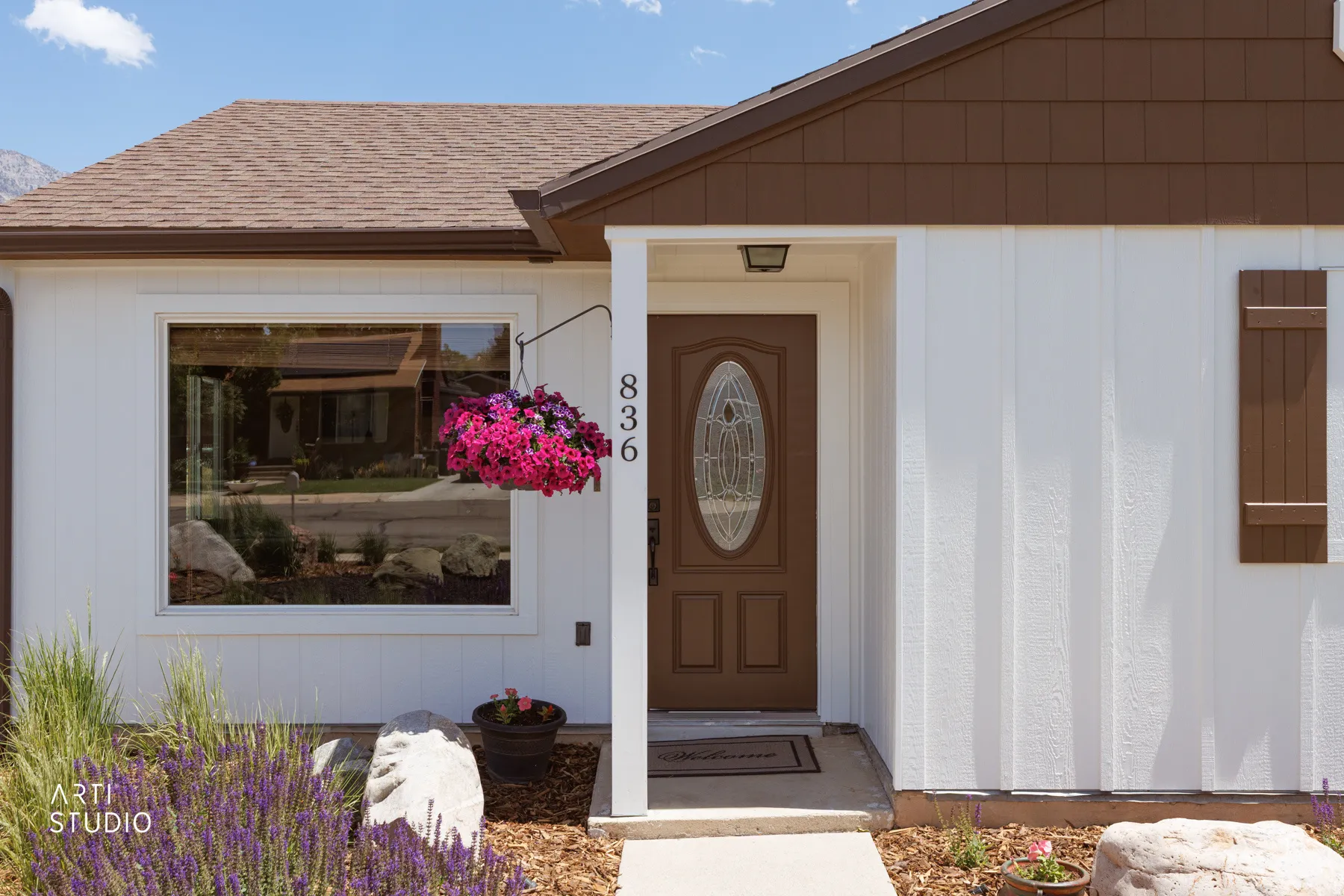 Modern exterior featuring white vertical siding and dark brown shake accents
