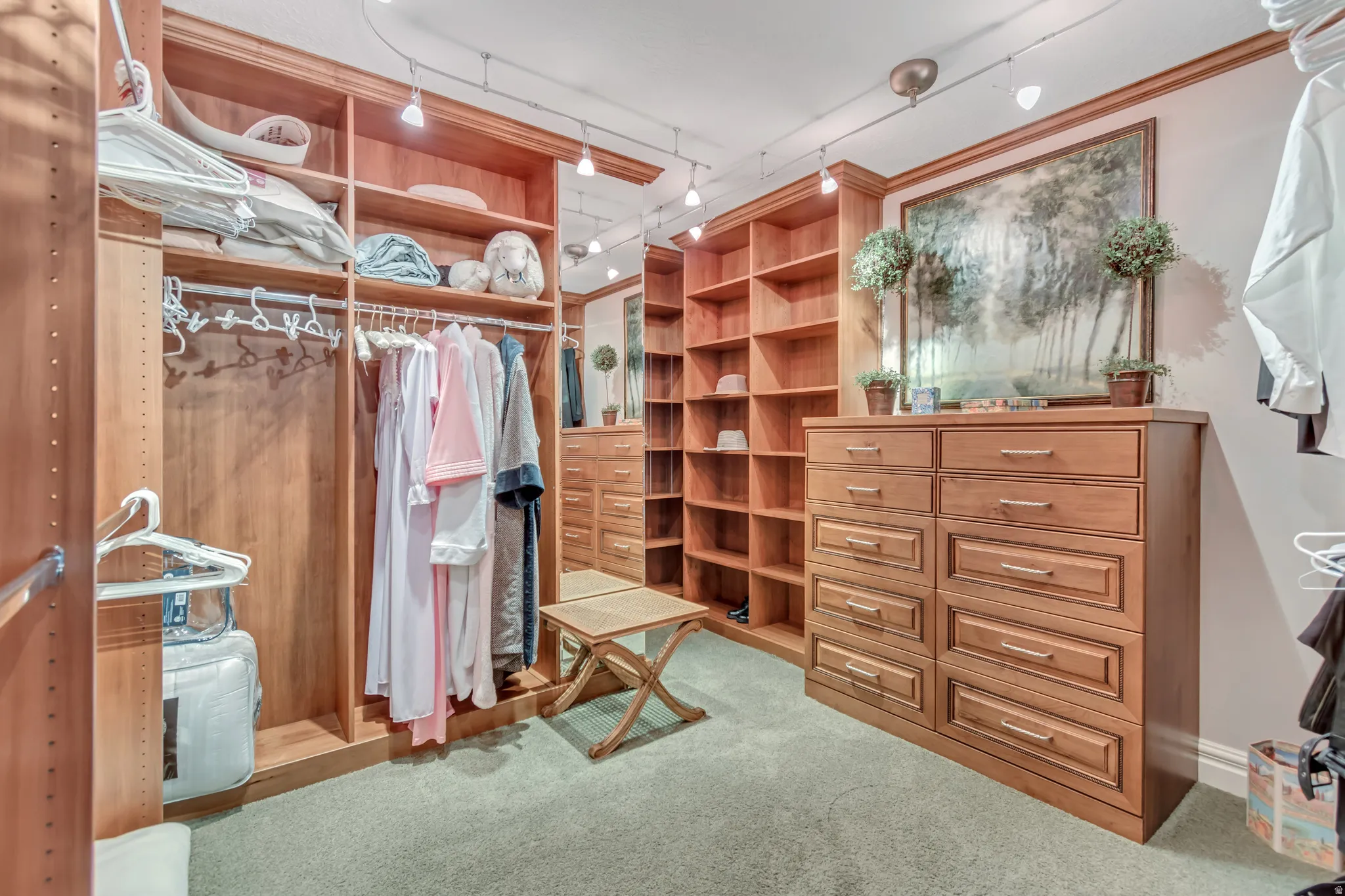 Master bedroom closet with custom wood-finish system featuring integrated shelving, hanging rods, and built-in drawer storage