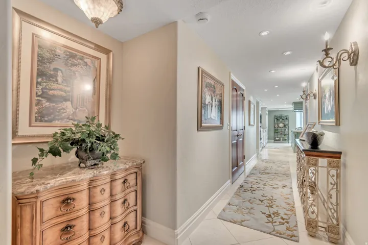 Hallway featuring recessed lighting, decorative wall sconces, and light-toned wall paint