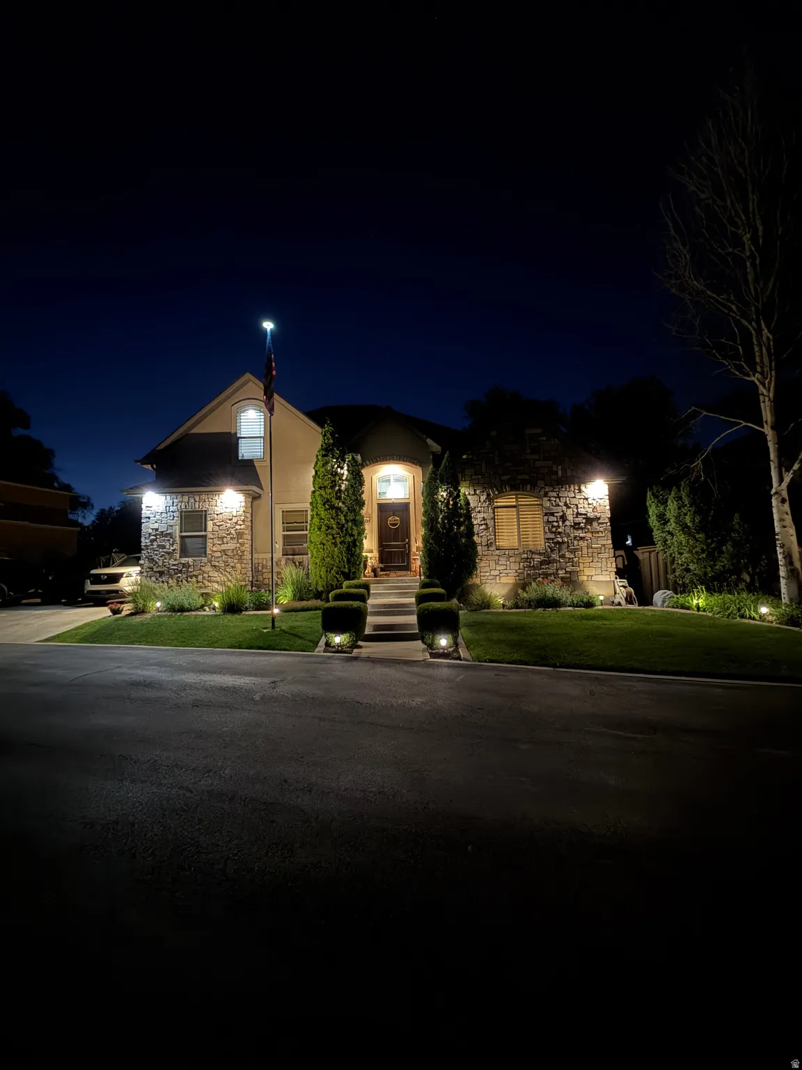 Stone and stucco exterior with extensive landscaping