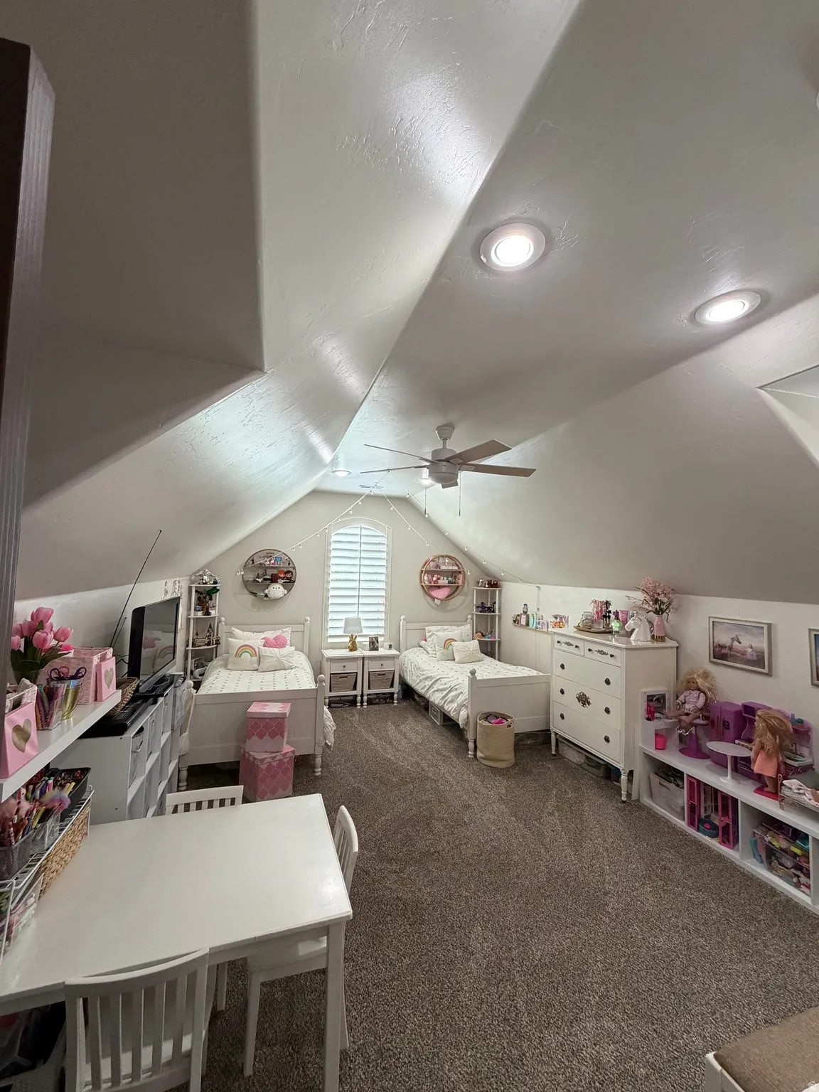 Spacious room featuring vaulted ceilings, recessed lighting, and a ceiling fan