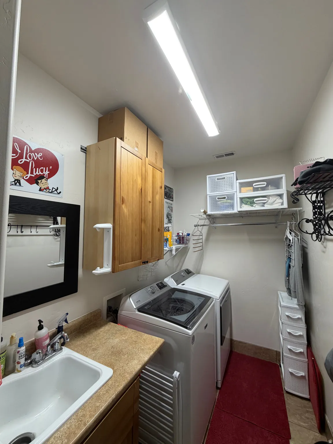 Dedicated laundry area featuring a utility sink, countertop, and built-in cabinetry