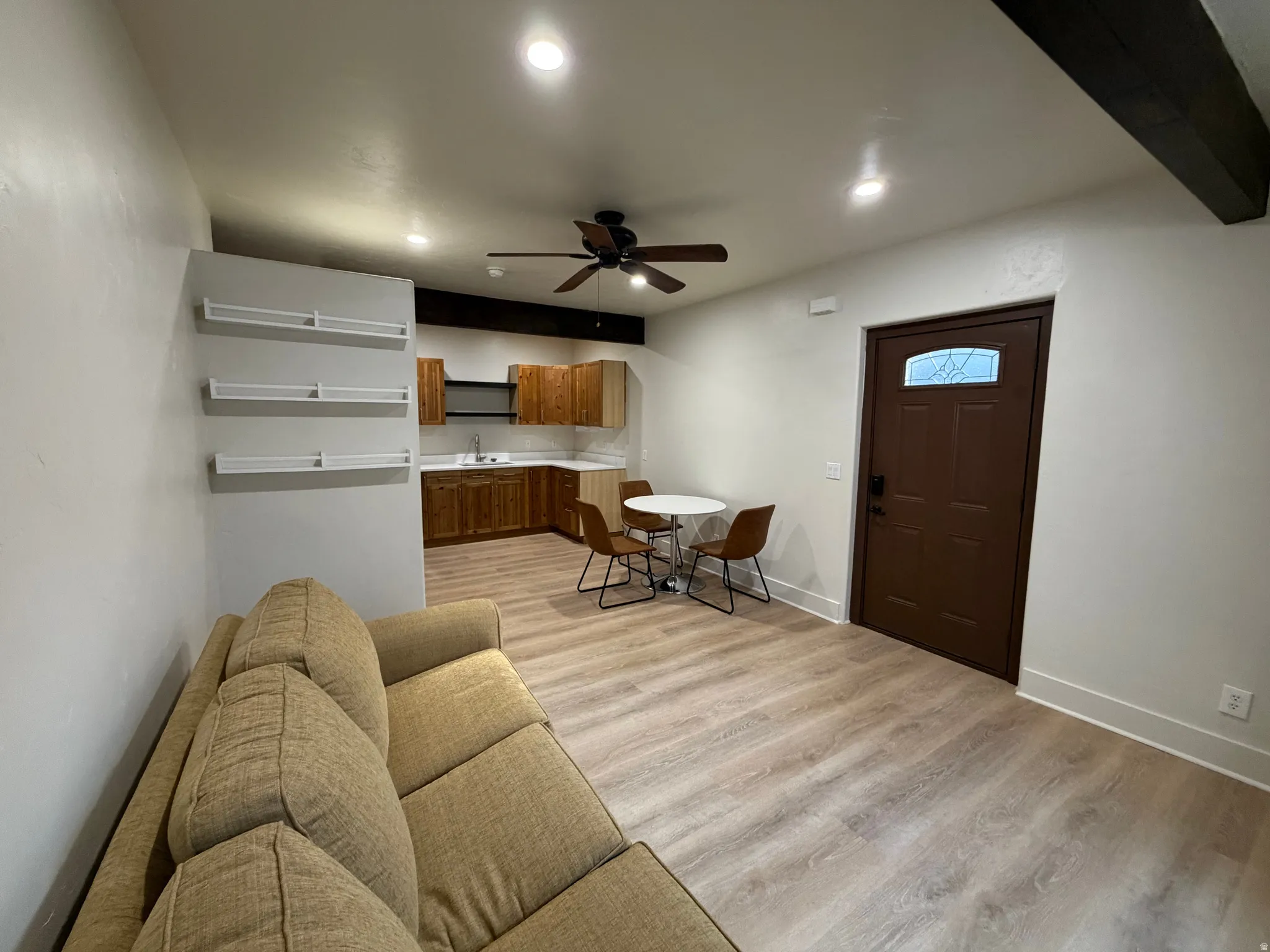 Open-concept living space featuring wood-finish flooring, recessed lighting, and a ceiling fan