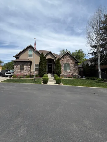 Stone and stucco exterior featuring multiple gables and an arched entry