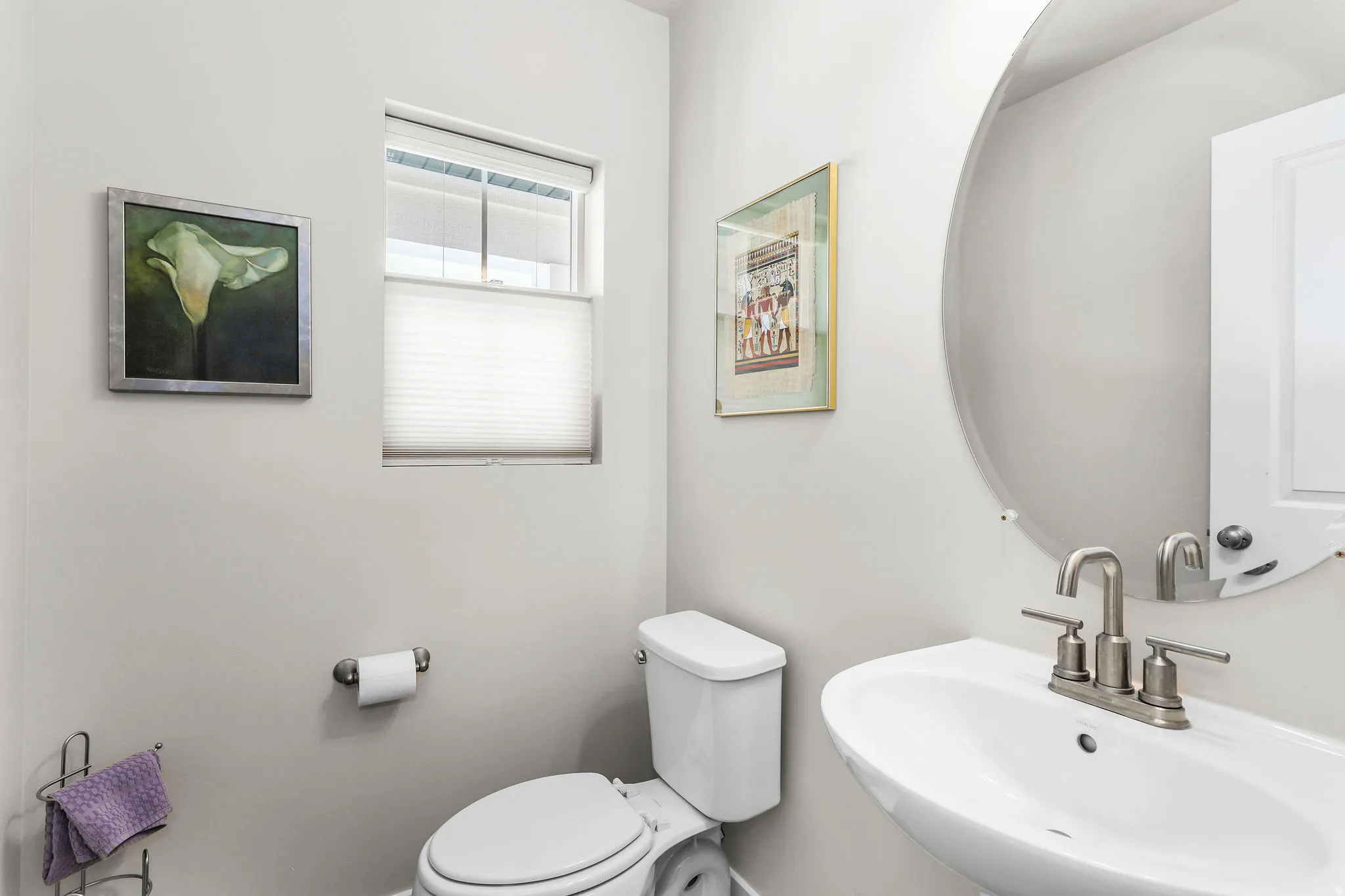 Contemporary powder room featuring a pedestal sink, brushed nickel faucet, and a large circular mirror