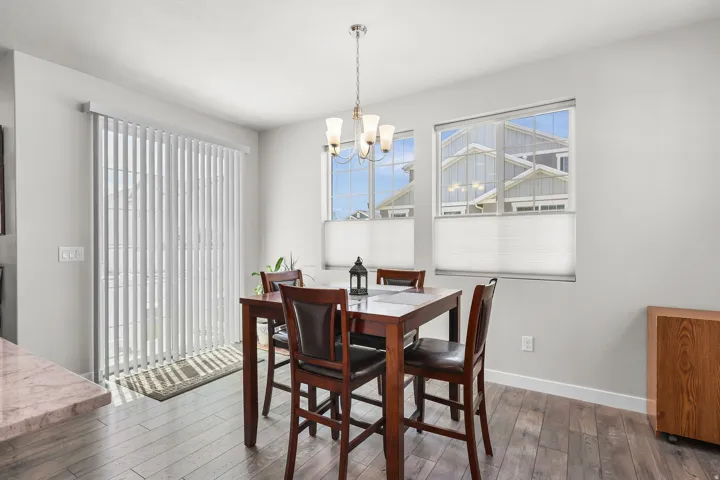 Dining area featuring wood-finish flooring and a contemporary chandelier