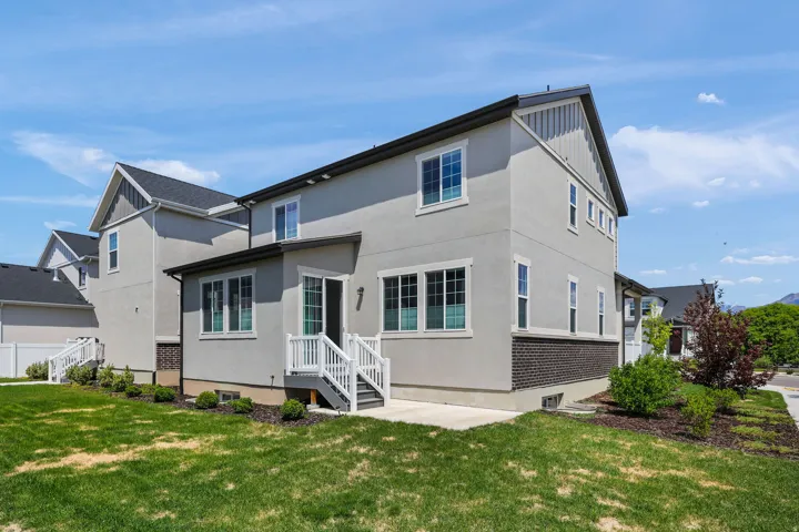 Modern stucco exterior with dark brick accents and white trim
