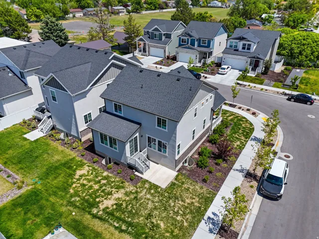 Contemporary multi-story residence featuring light gray siding with dark trim accents, a prominent front-facing gable, and a dark shingled roof