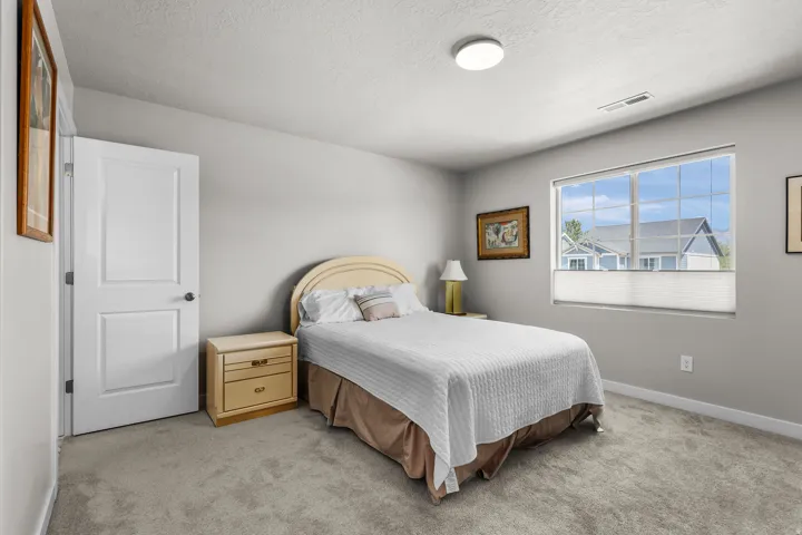 Spacious room with a large window, light gray walls, and gray carpet flooring